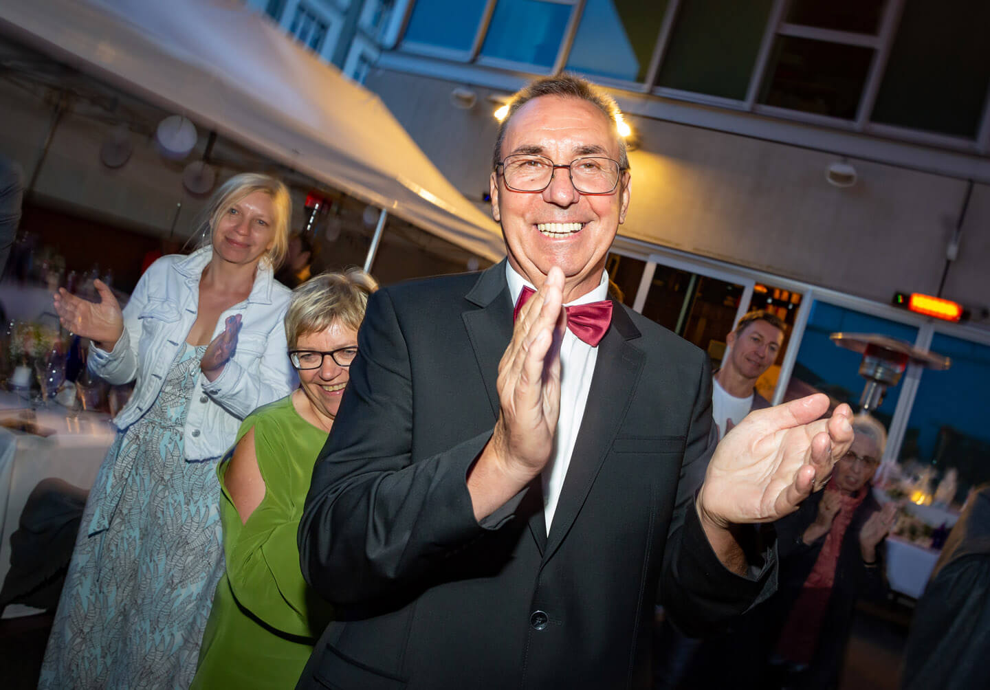 Gäste klatschen zum Baumstamm sägen