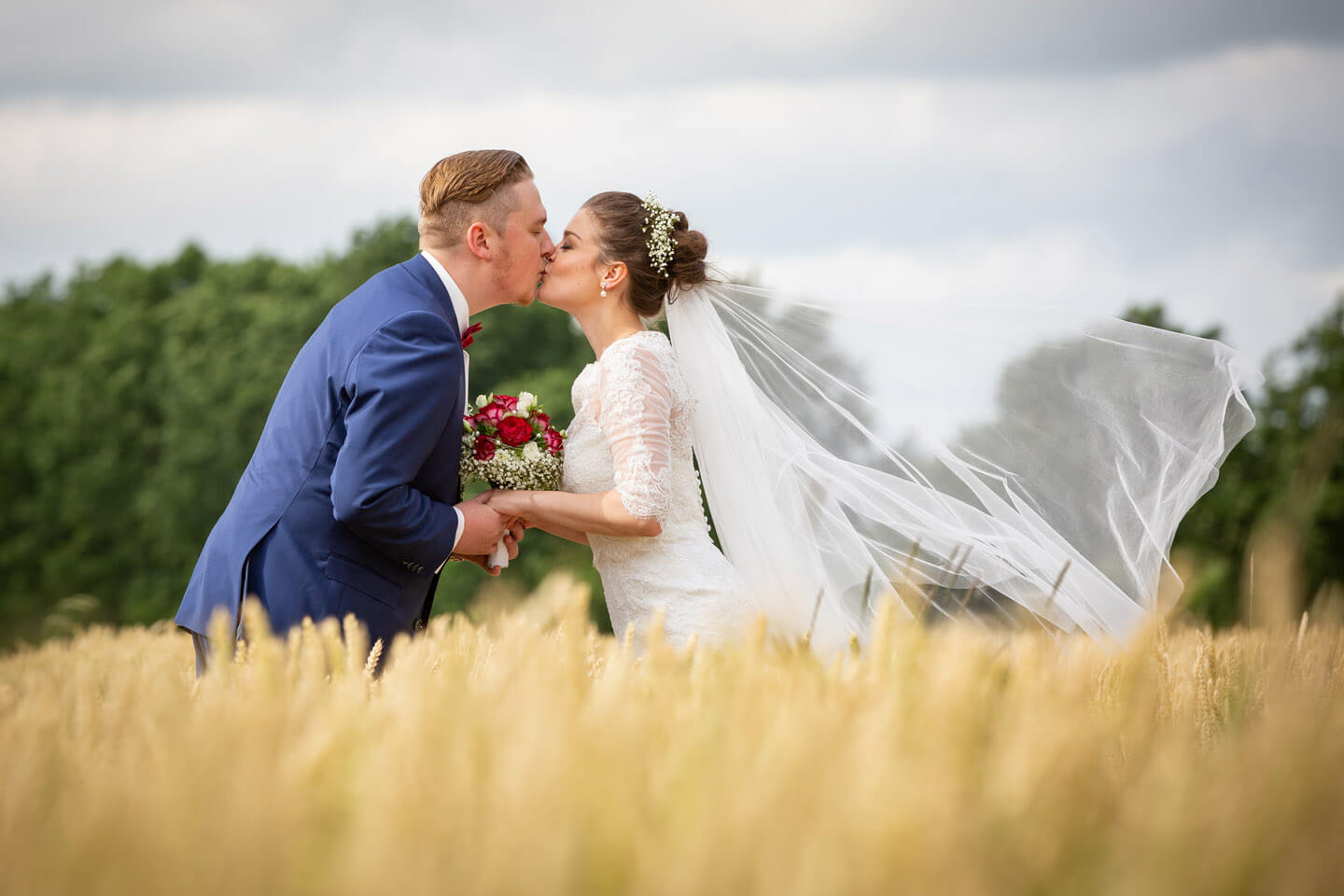 Brautpaar küsst sich im Kornfeld