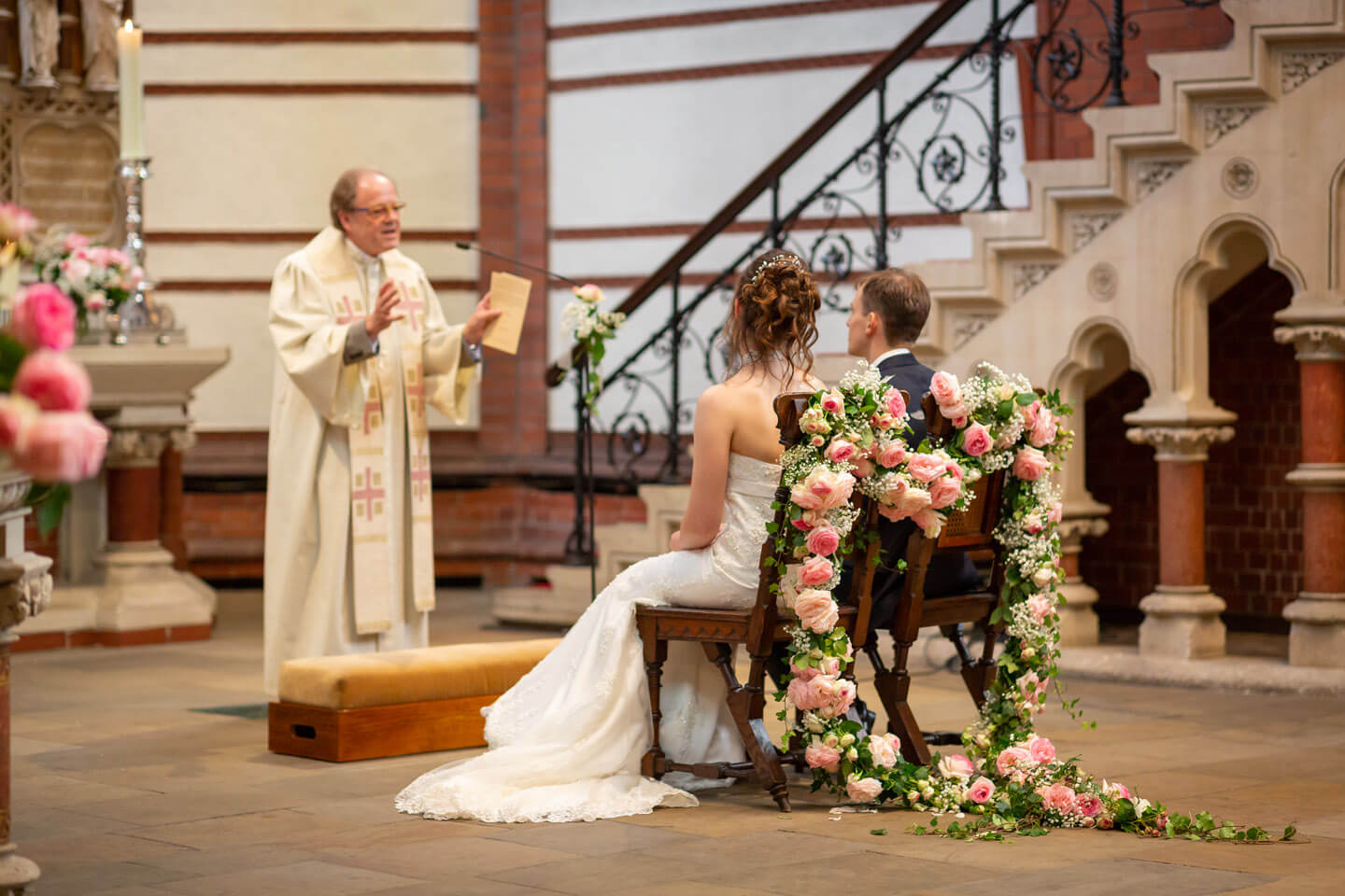 Brautpaar sitzt auf blumengeschmückten Stühlen