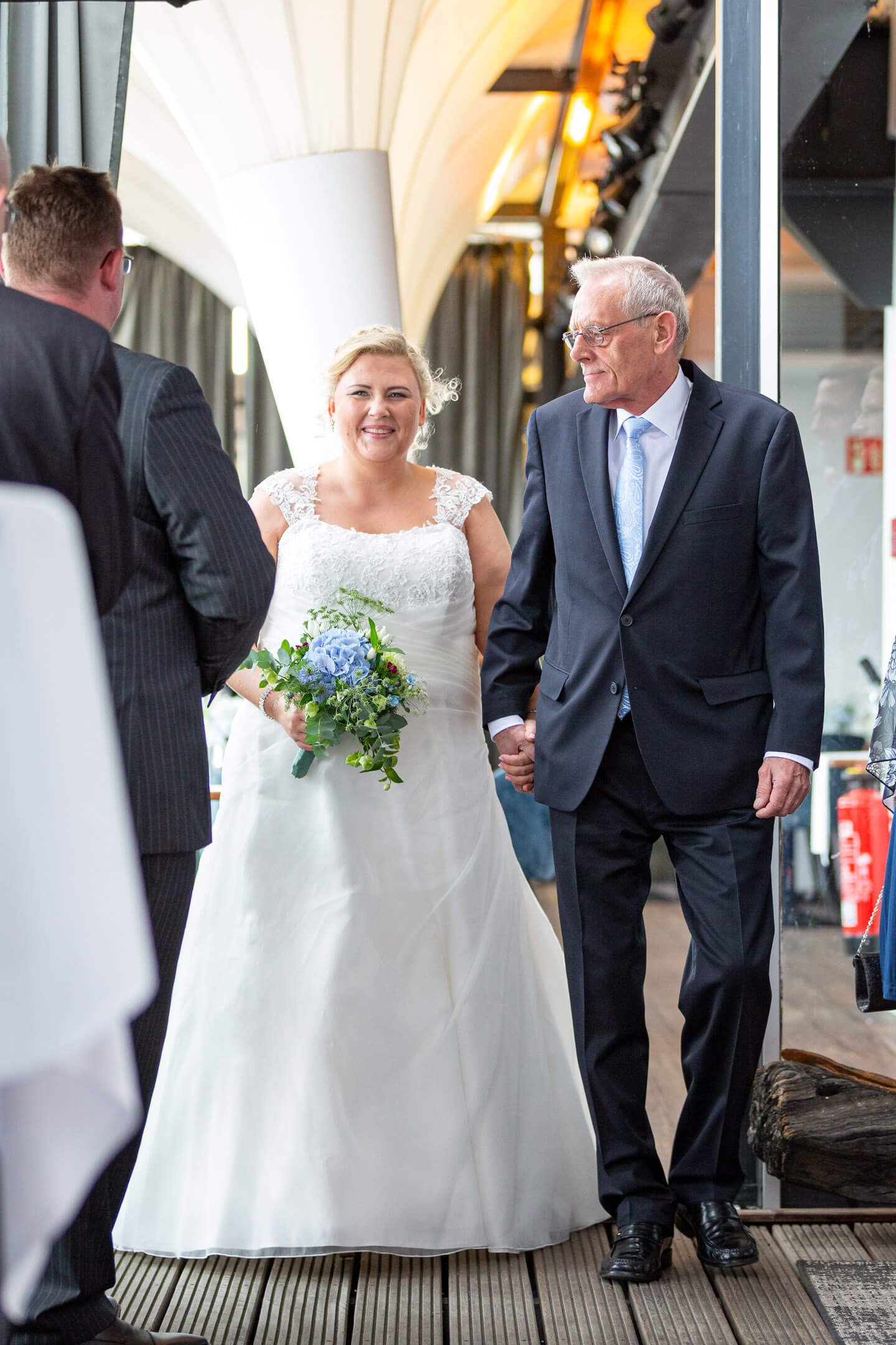 Braut wird von ihrem Vater zur Trauung begleitet