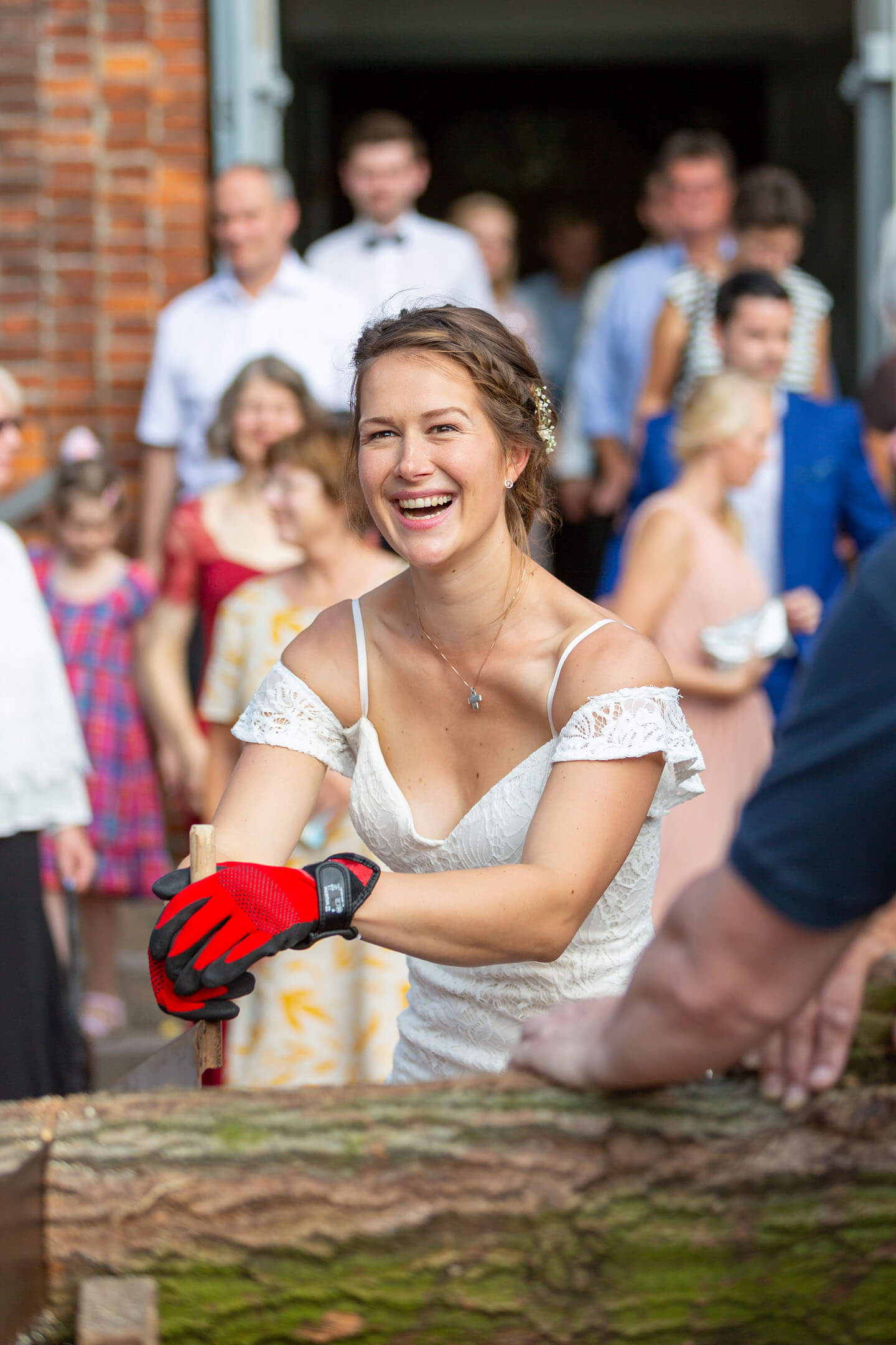 Braut beim Baumstammsägen