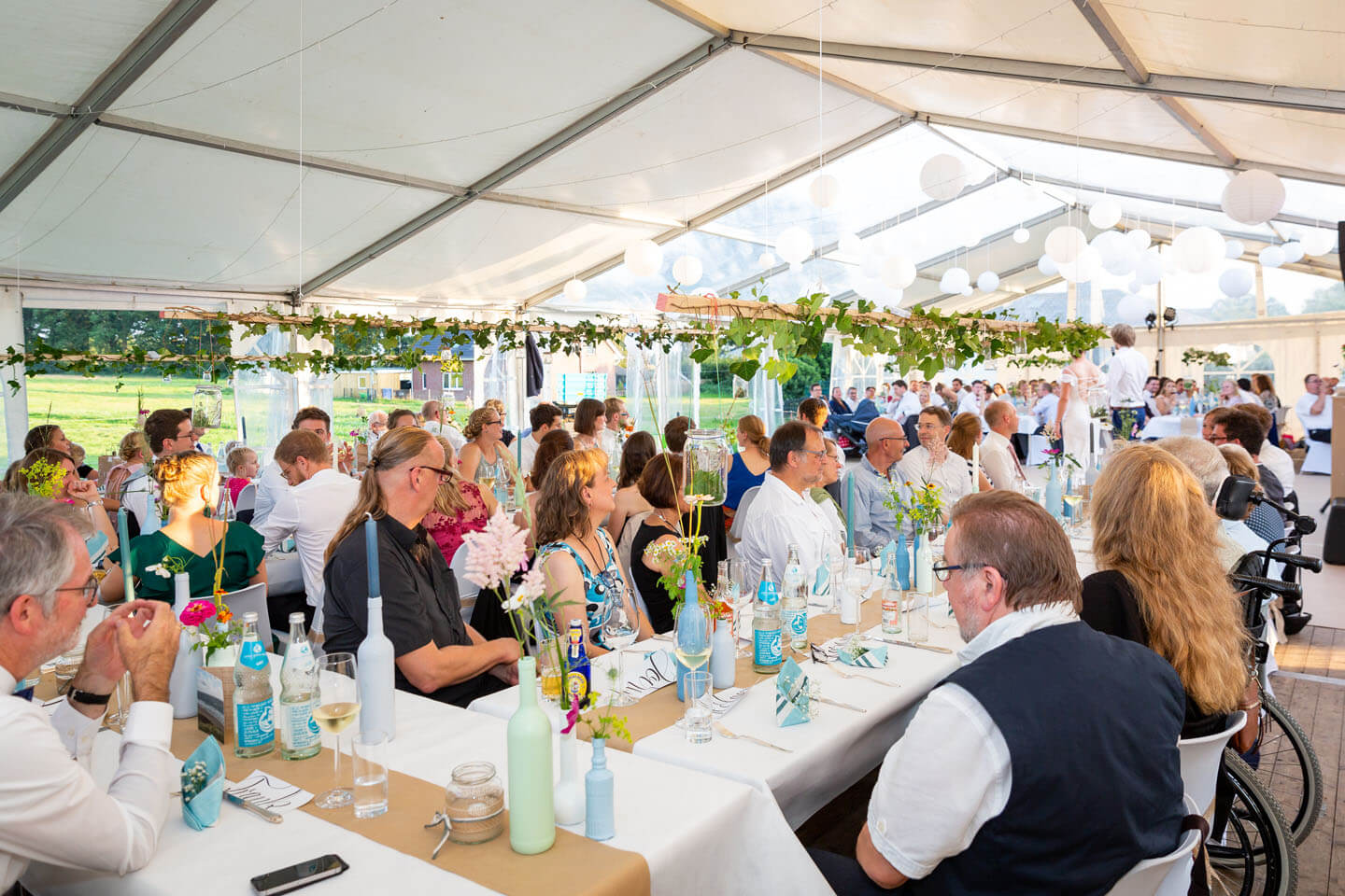 Hochzeitsgesellschaft bei sommerlicher Zelthochzeit