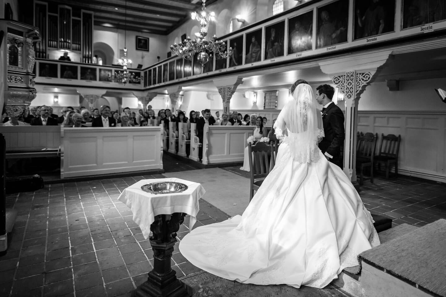 Hochzeitspaar blickt auf die Hochzeitsgesellschaft in der Sinstofer Kirche in Harburg