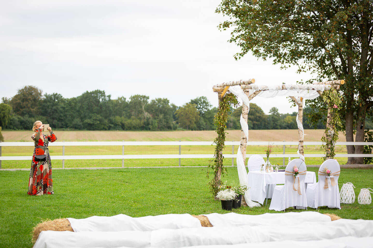 Ein Bogen aus Birken und Blumen für die freie Trauung einer Gartenhochzeit