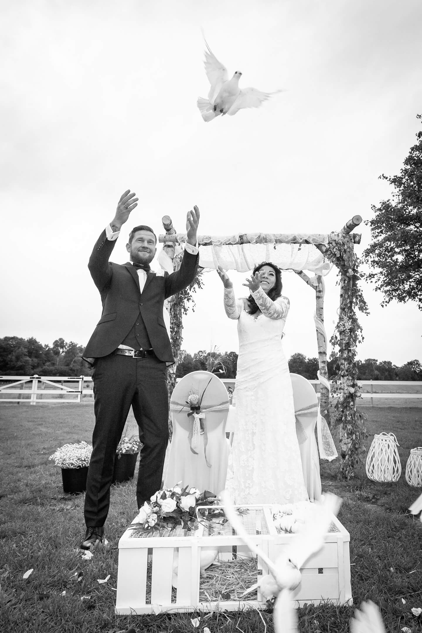 Brautpaar lässt weiße Tauben fliegen