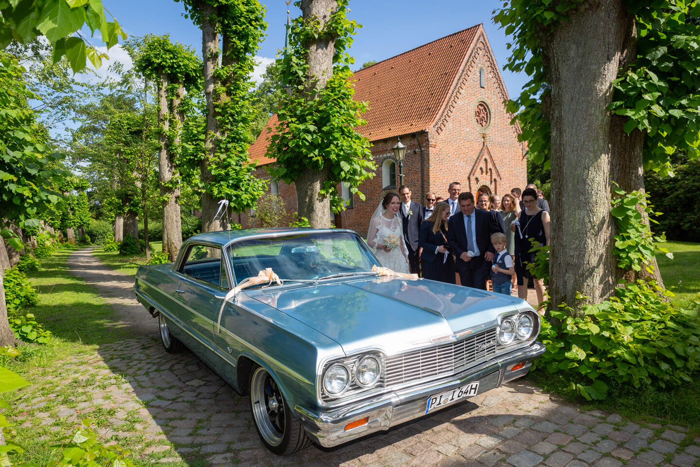 Hochzeitsauto steht vor der Kirche bereit.