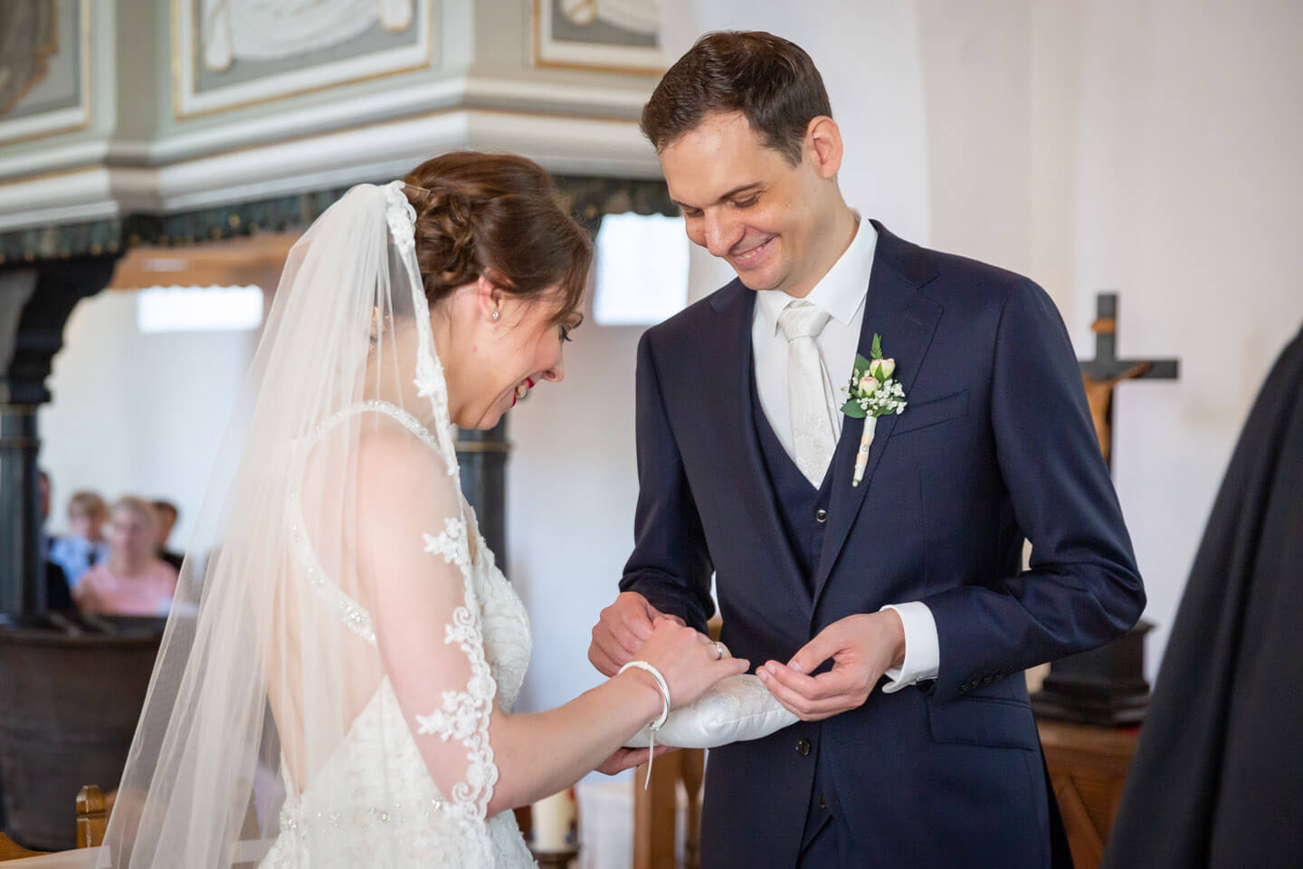 Brautpaar nimmt die Trauringe vom Ringkissen