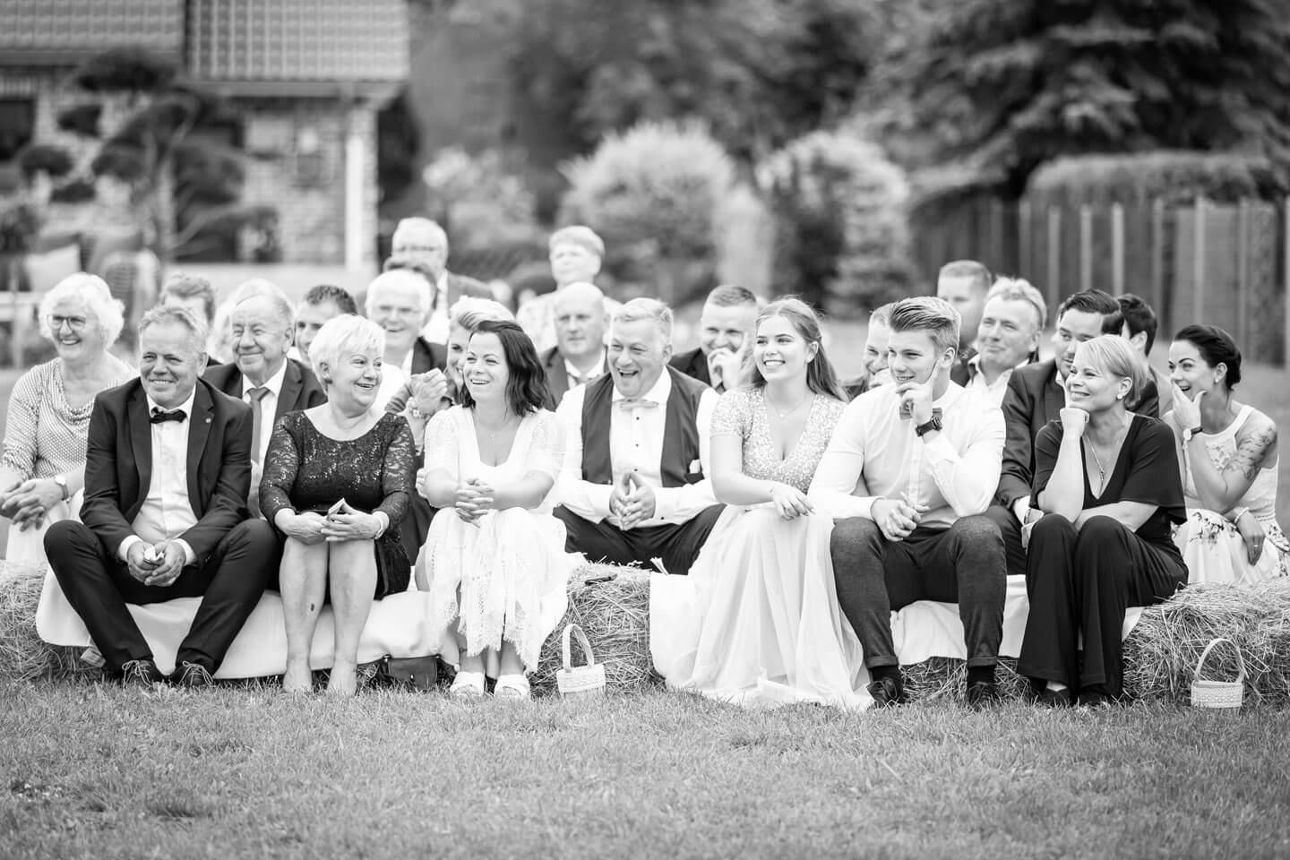 Gäste sitzen bei freier Trauung auf Heuballen