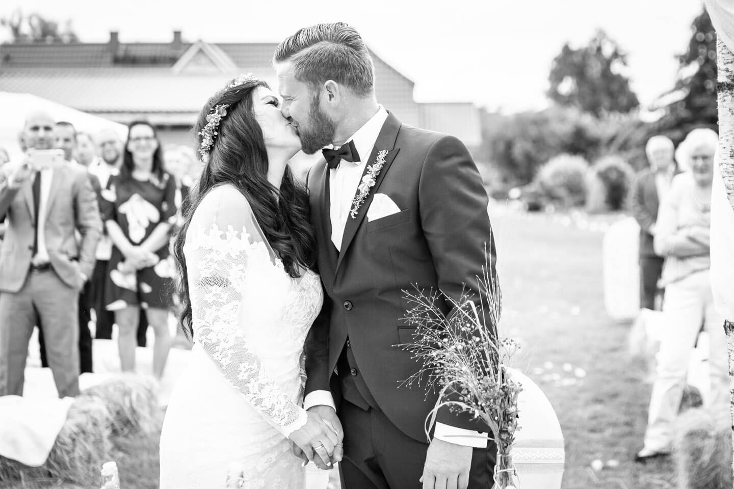 Vermählungskuss bei Gartenhochzeit unter freiem Himmel.
