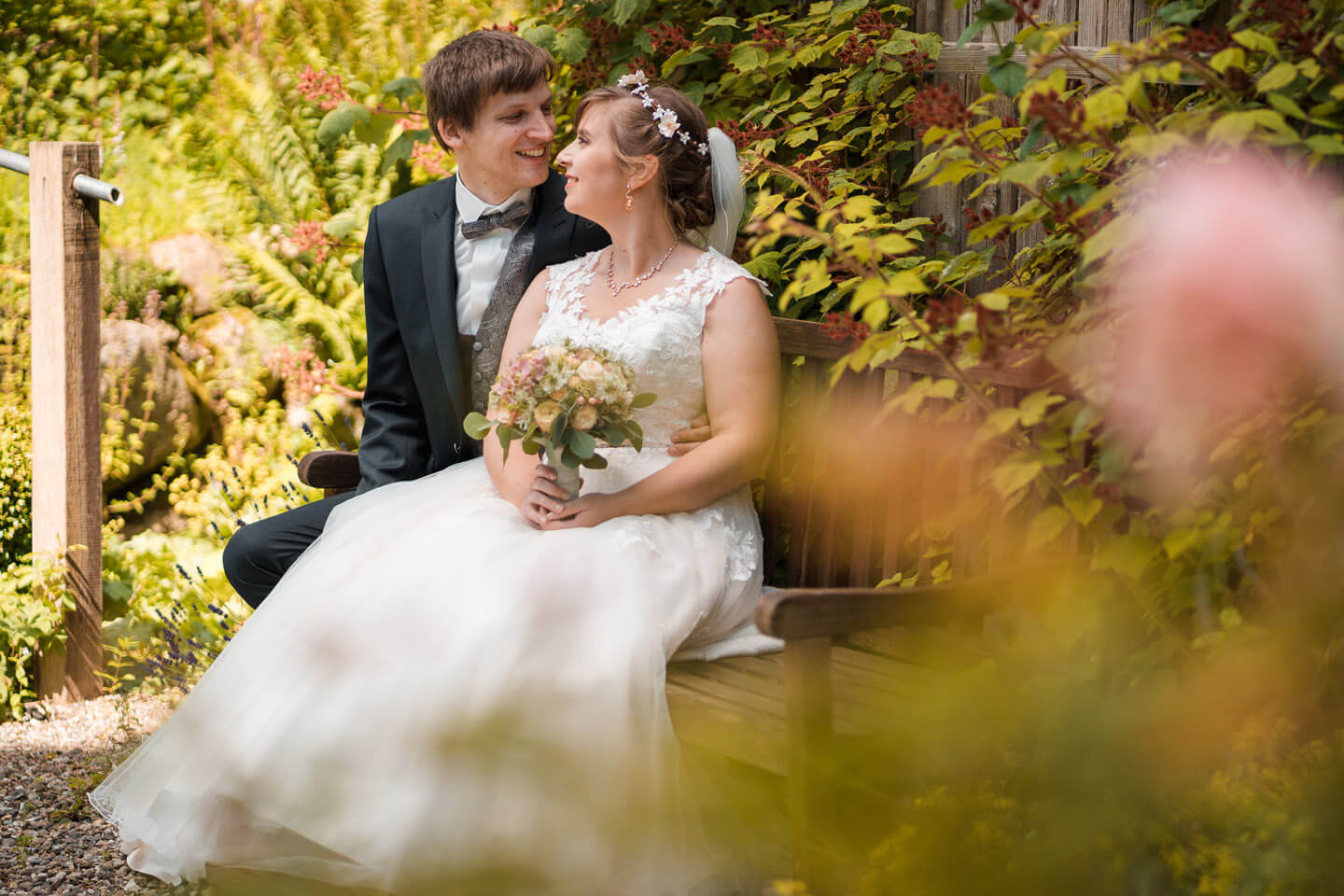 Hochzeitsfotos auf einer Gartenbank