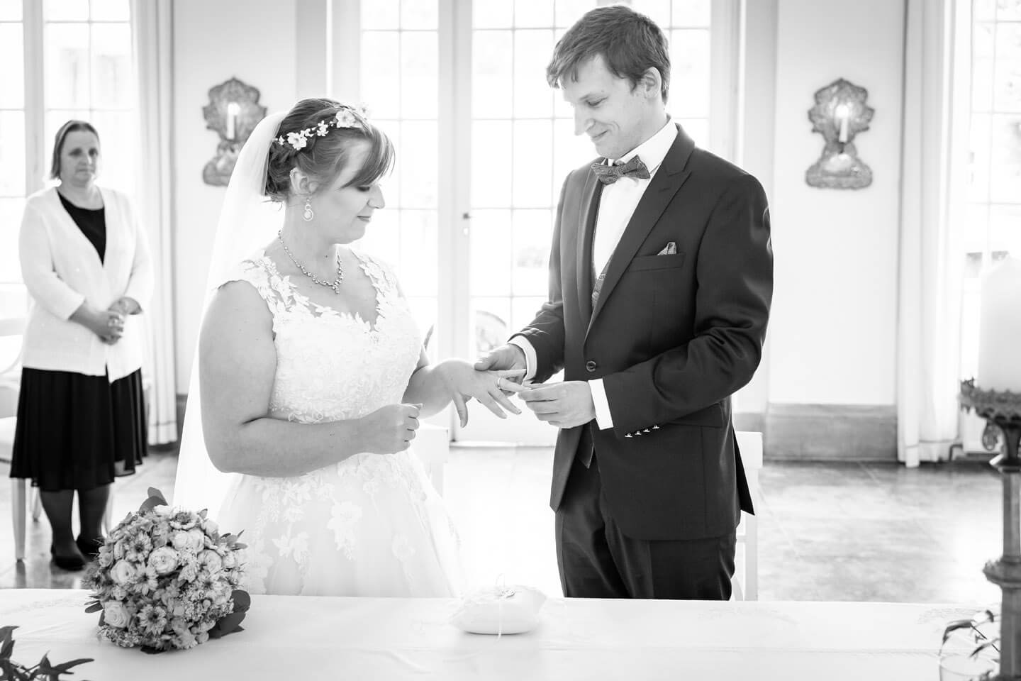 Bräutigam steckt der Braut den Ring auf den Finger