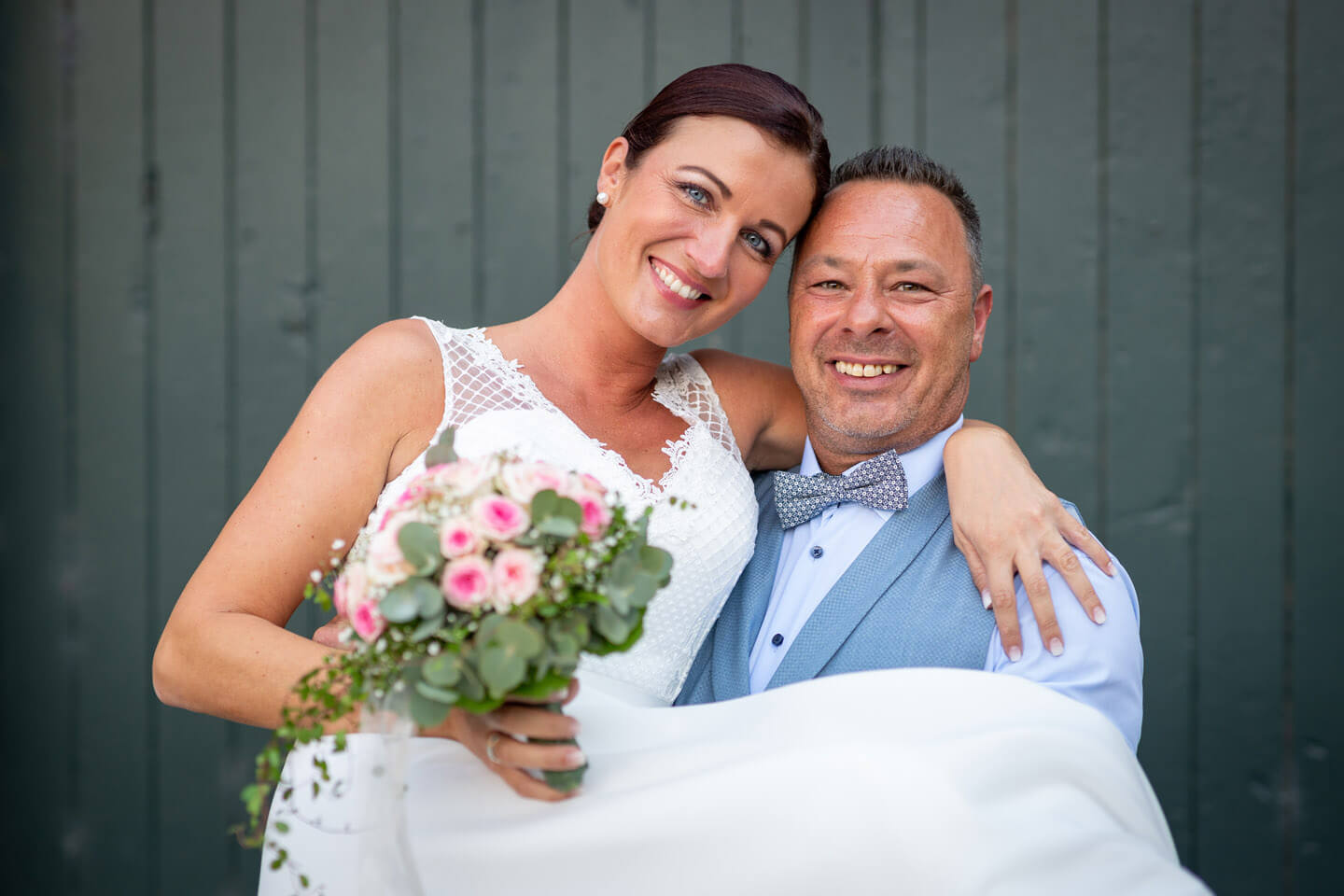 Bräutigam trägt die Braut auf Händen.