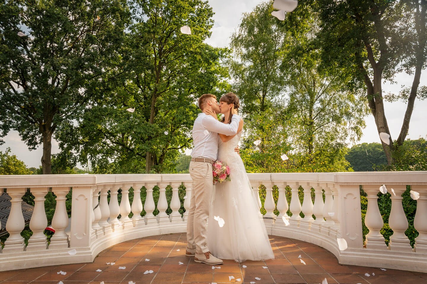 Weiße Rosenblättervregnen auf das Brautpaar