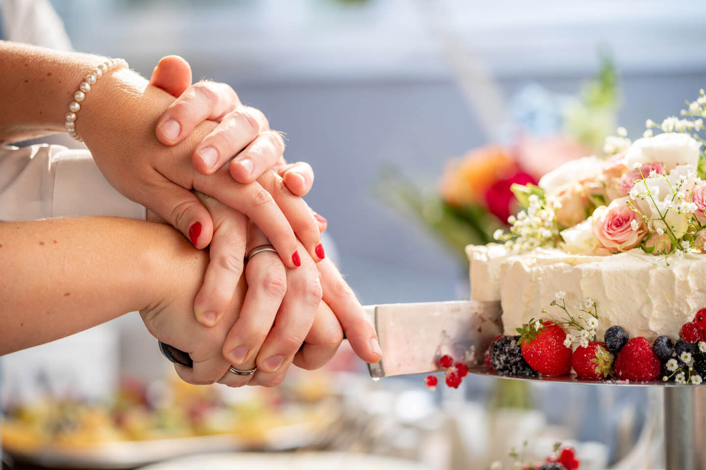 Anschnitt der Hochzeitstorte. Wer hält die Hand oben?