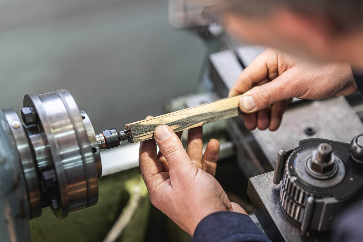 Handwerkerhände an der Drehmaschine