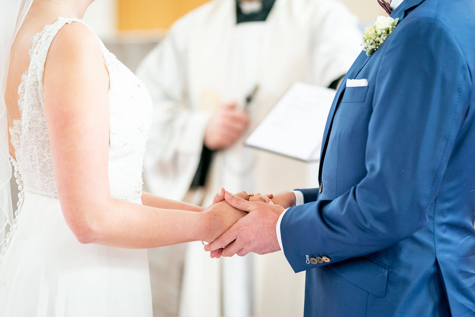 Brautpaar hält sich am Atar die Hände. Fotograf Florian Läufer aus drückte im richtigen Moment auf den Auslöser.