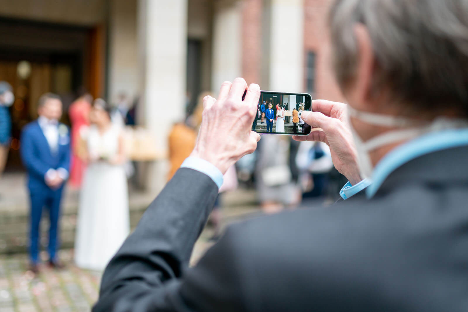 Handyfoto vom Brautpaar vor der Kirche.