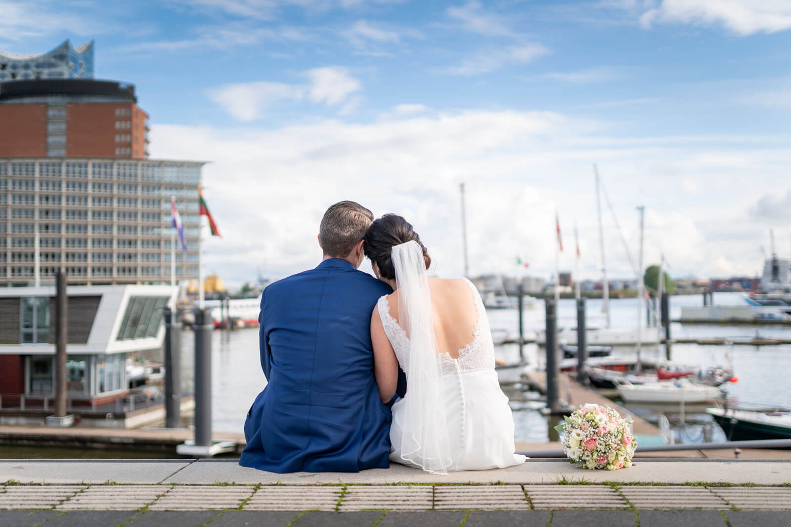 Brautpaar an der Elbe mit Elbphilharmonie im Hintergrund.