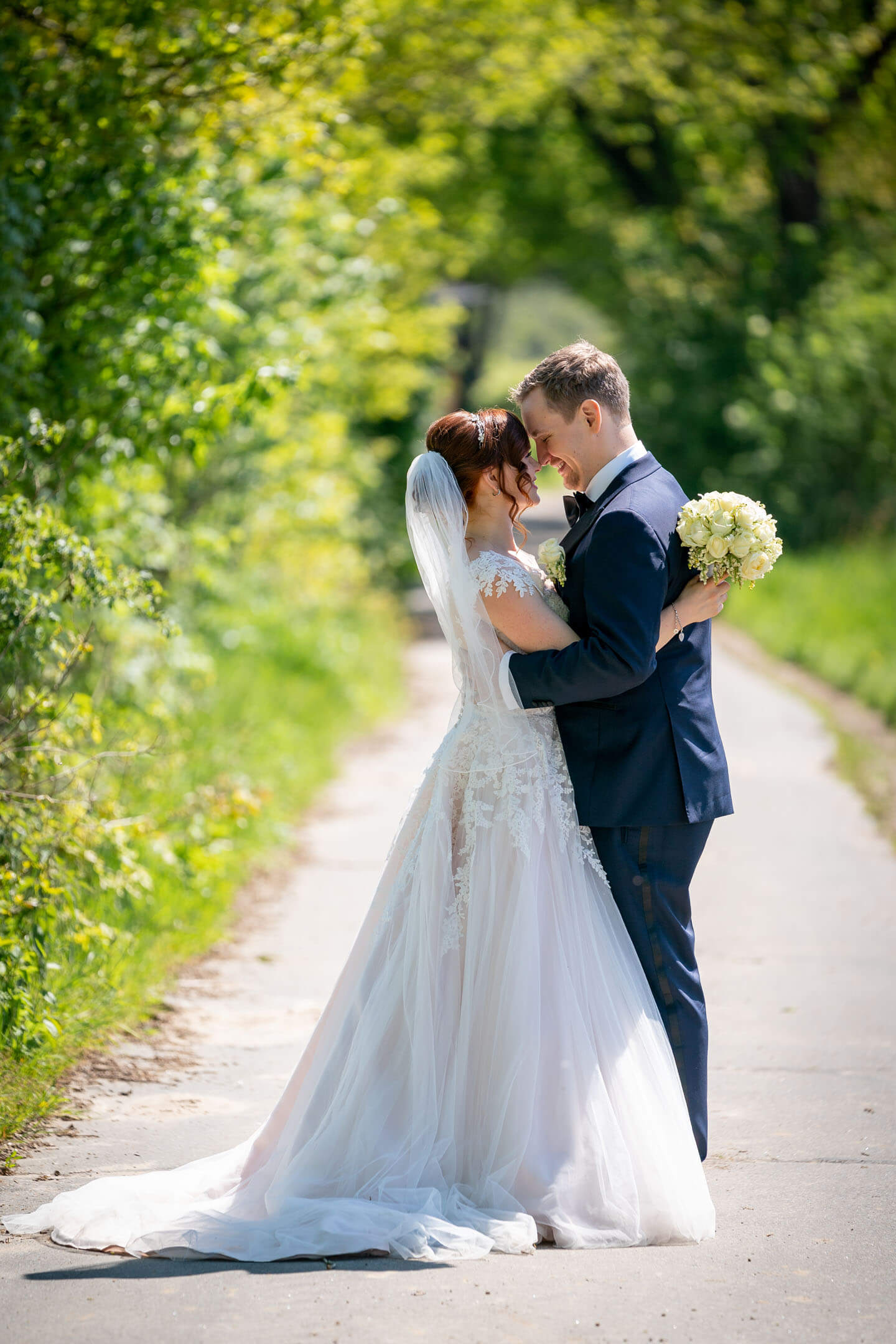 Brautpaar auf einer Baumallee