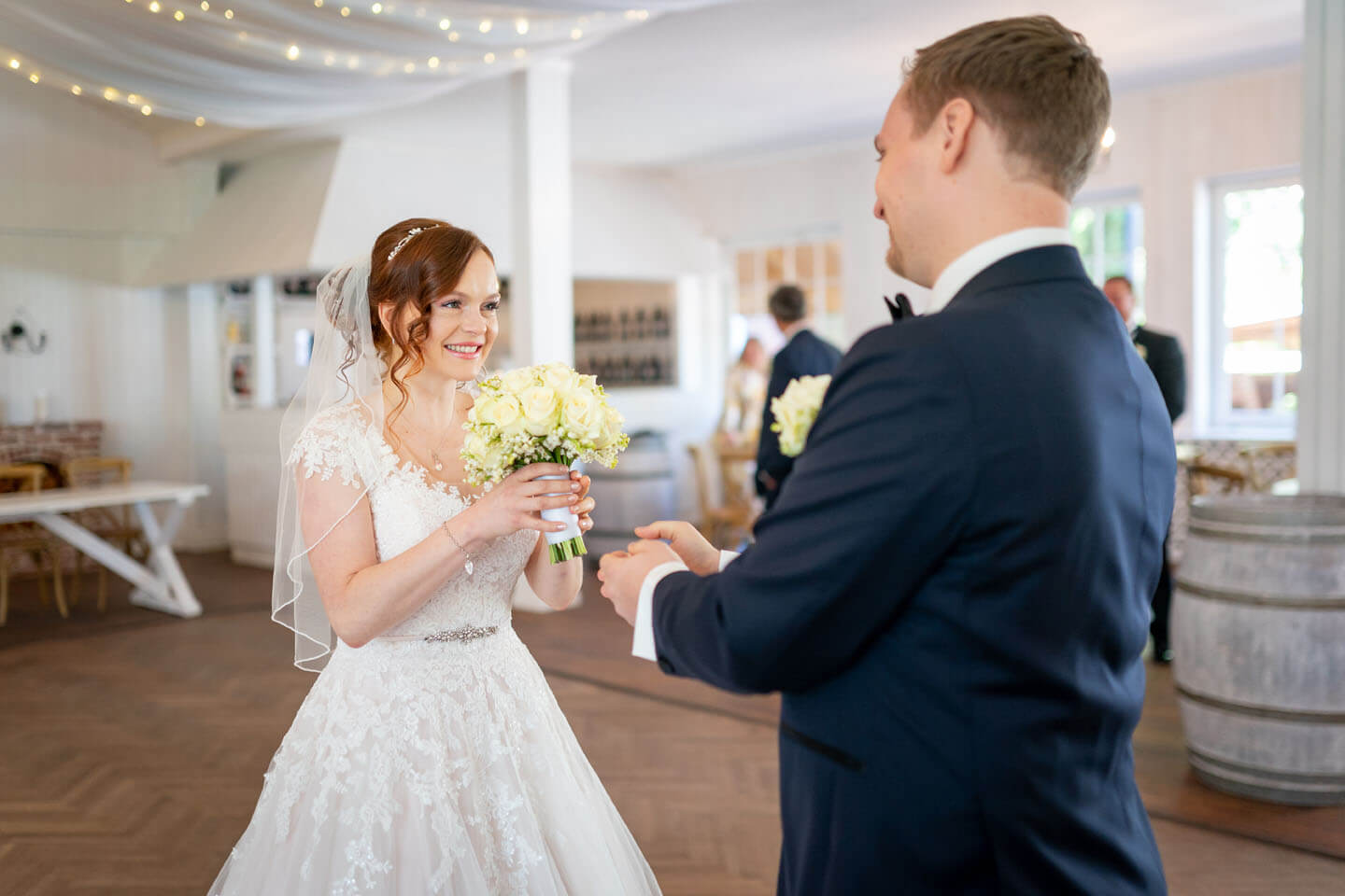 Bräutigam reicht beim first Look Shooting seiner Braut den Brautstrauss.