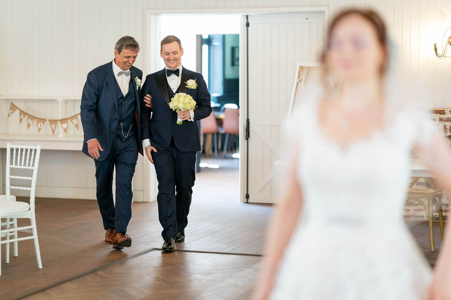 Bräutigam wird in den Saal zum First Look Shooting geführt.