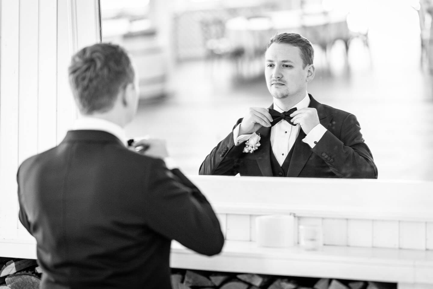 Bräutigam zupft sich die Fliege kurz vor dem Shooting zurecht.