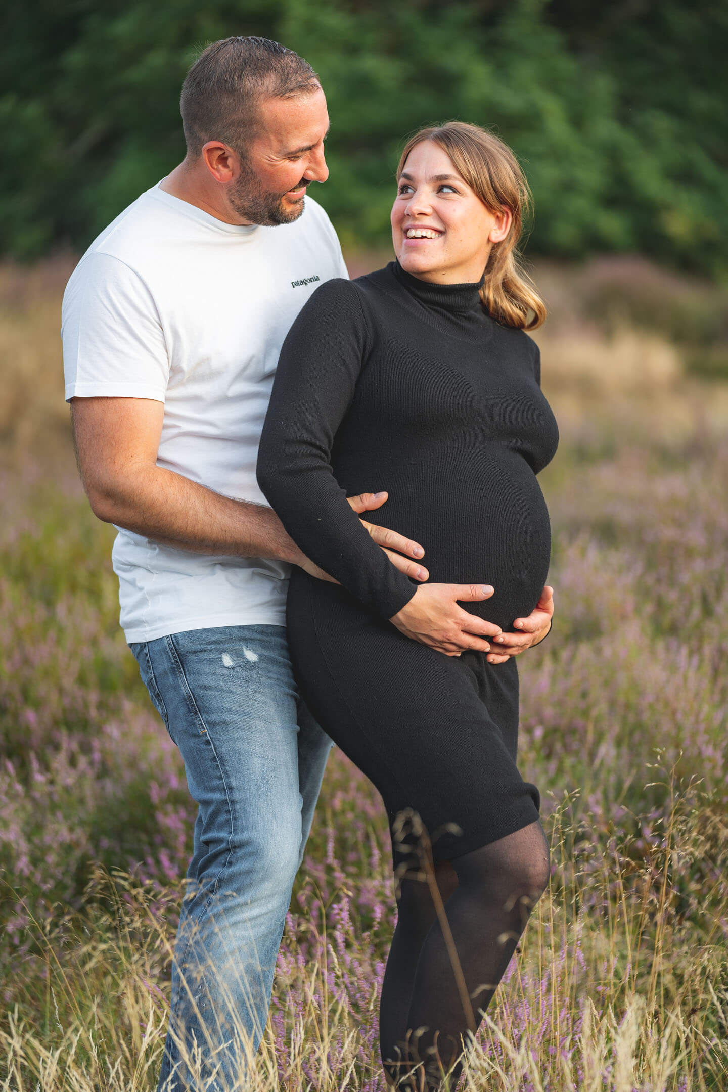 Glückliches Paar beim Babybauch-Fotoshooting