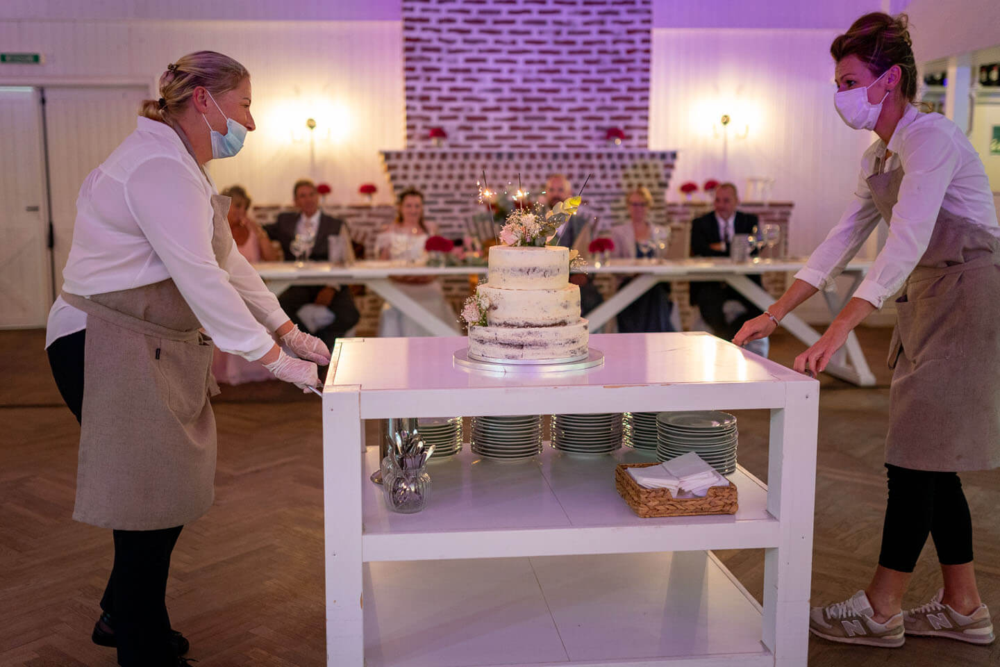 Das Servicepersonal bringt die Hochzeitstorte in den Saal