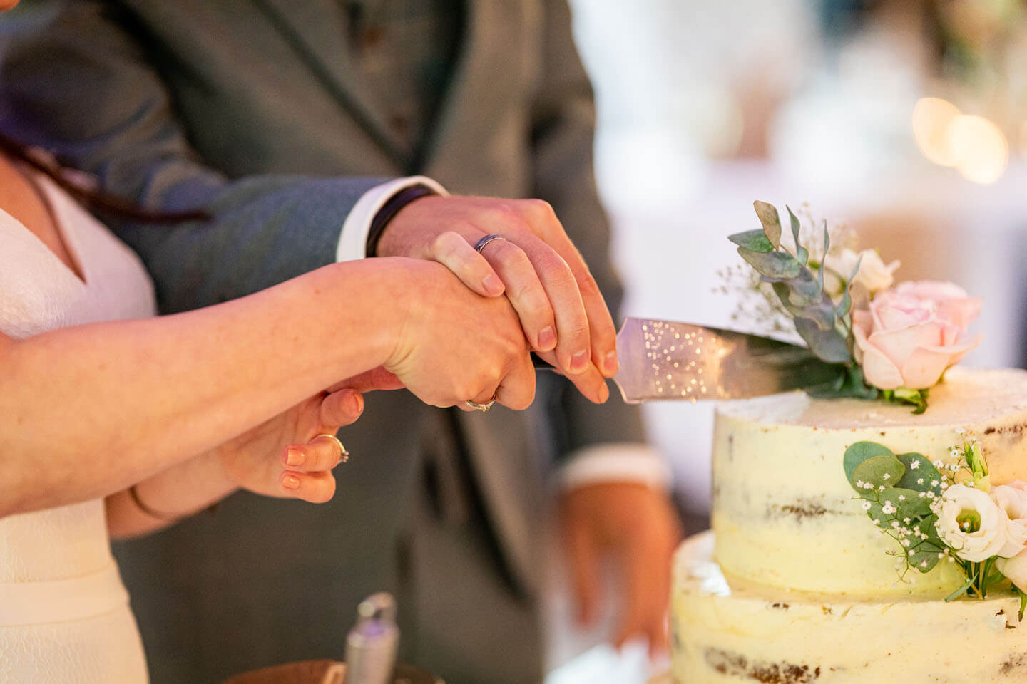Anschnitt der Hochzeitstorte mit dem Tortenmesser