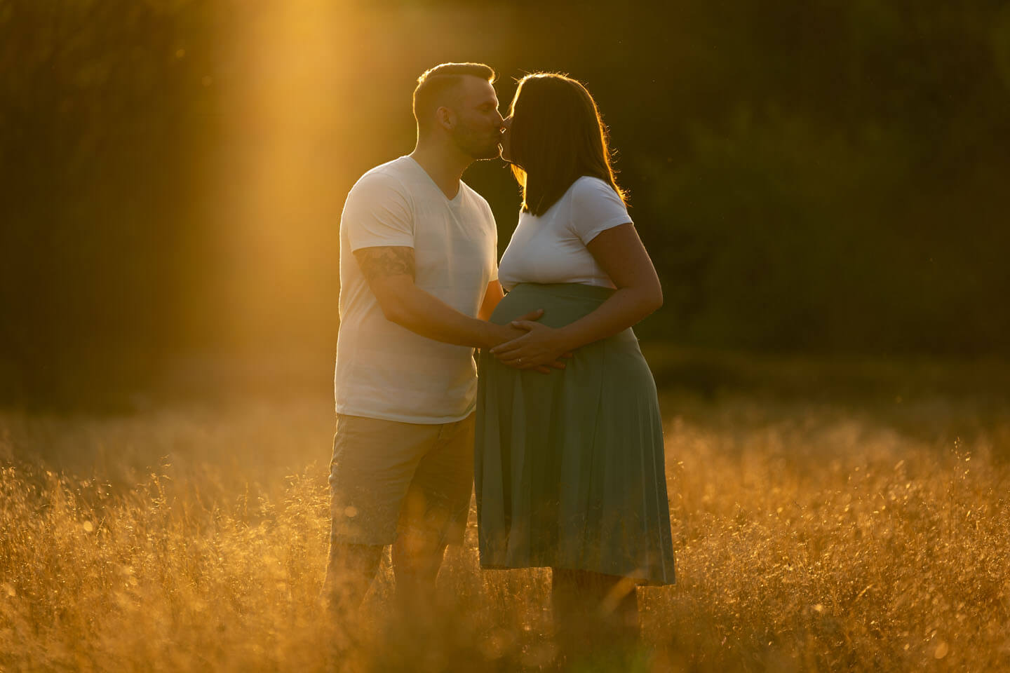 Das Gegenlicht der untergehenden Sonne malte die Lichtkante um die Köpfe von Matthias & Franziska beim Babybauch-Shooting