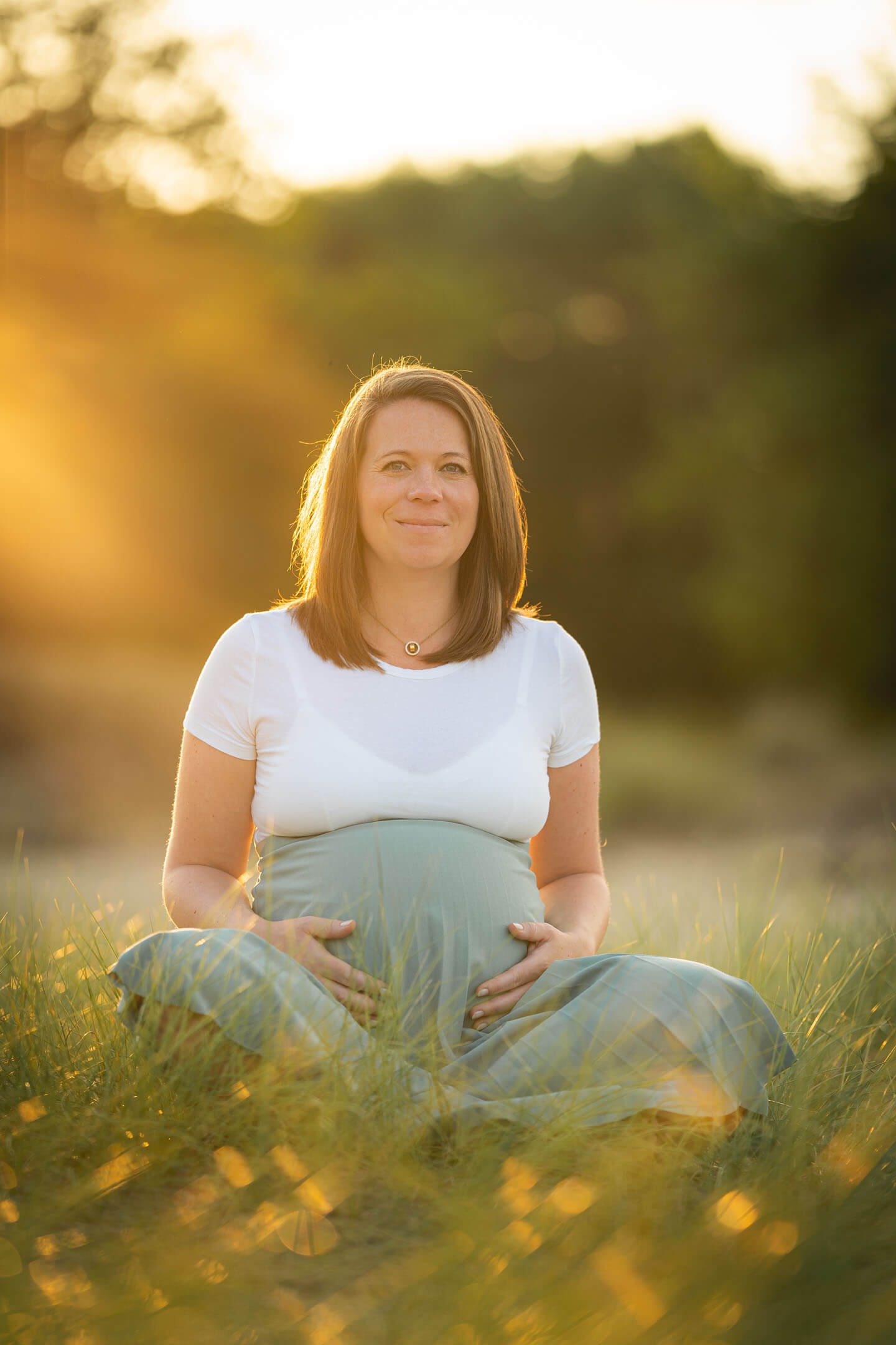 Franziska mit ihrem Babybauch in der späten Abendsonne