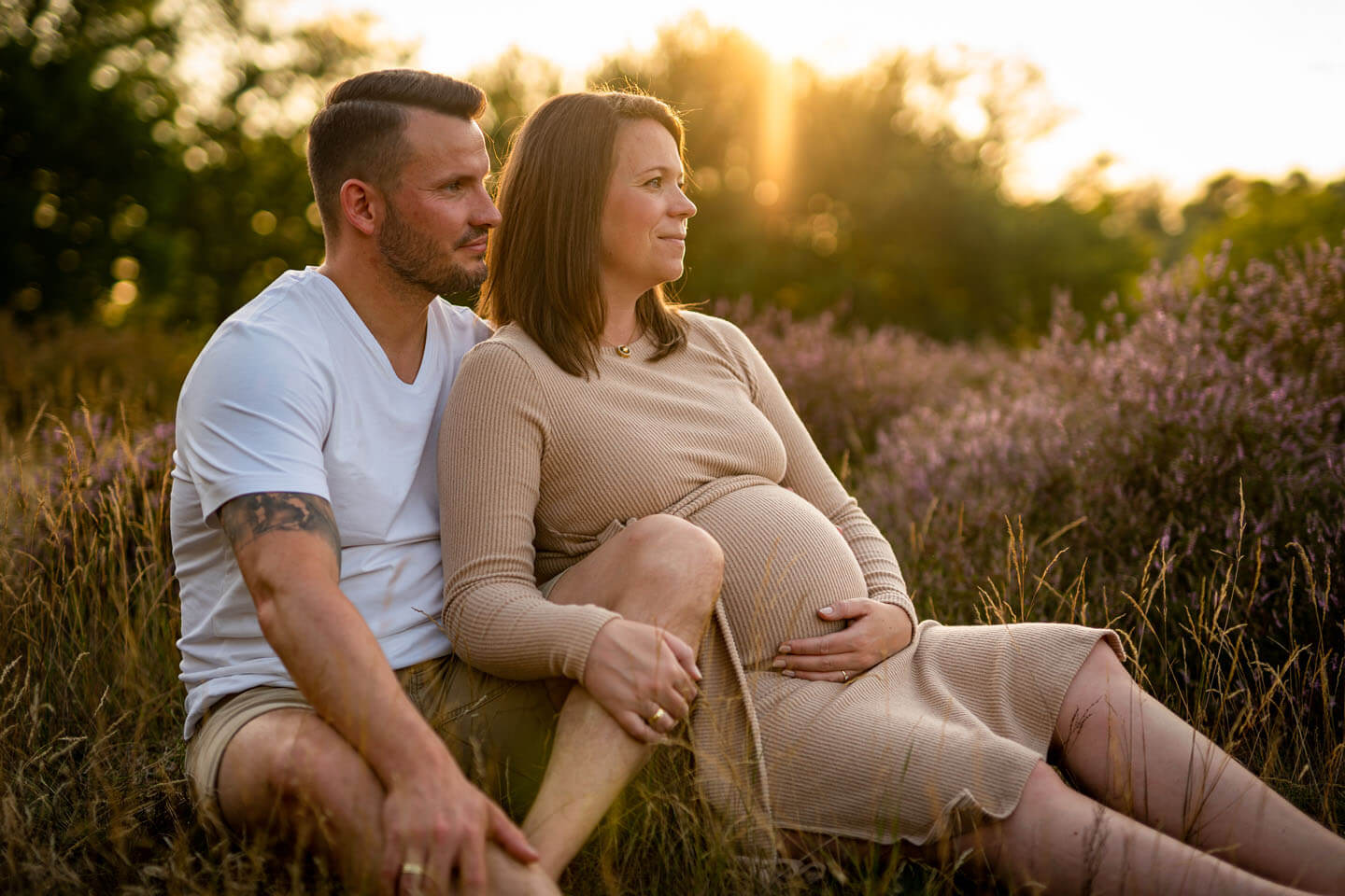 Ein Outdoor Babybauch-Shooting mit blühender heide im letzten Abendlicht der Sonne