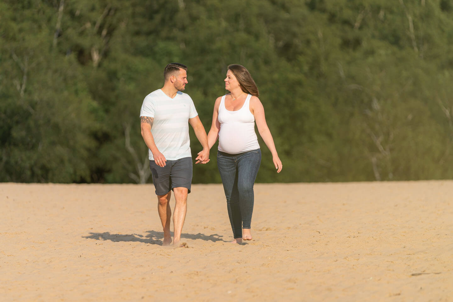 Paar geht Hand in Hand auf Sand