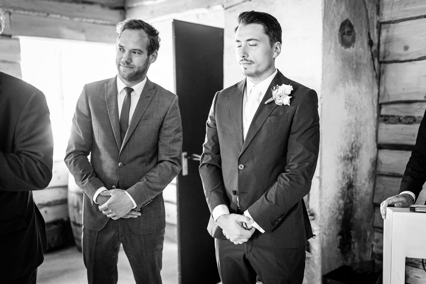 Bräutigam wartet mit geschlossenen Augen auf die Braut.