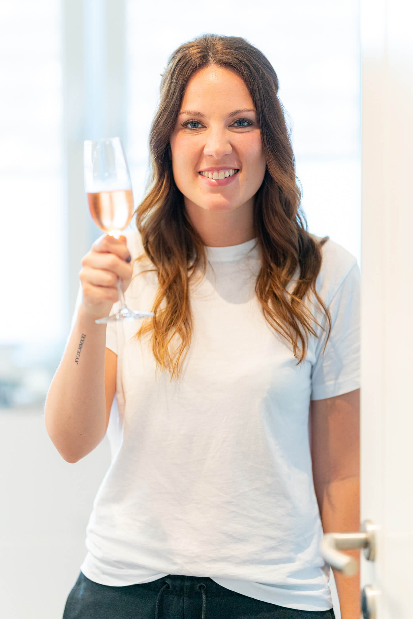 Cheers - die Braut beim Getting Ready mit einem Sekt in der Hand