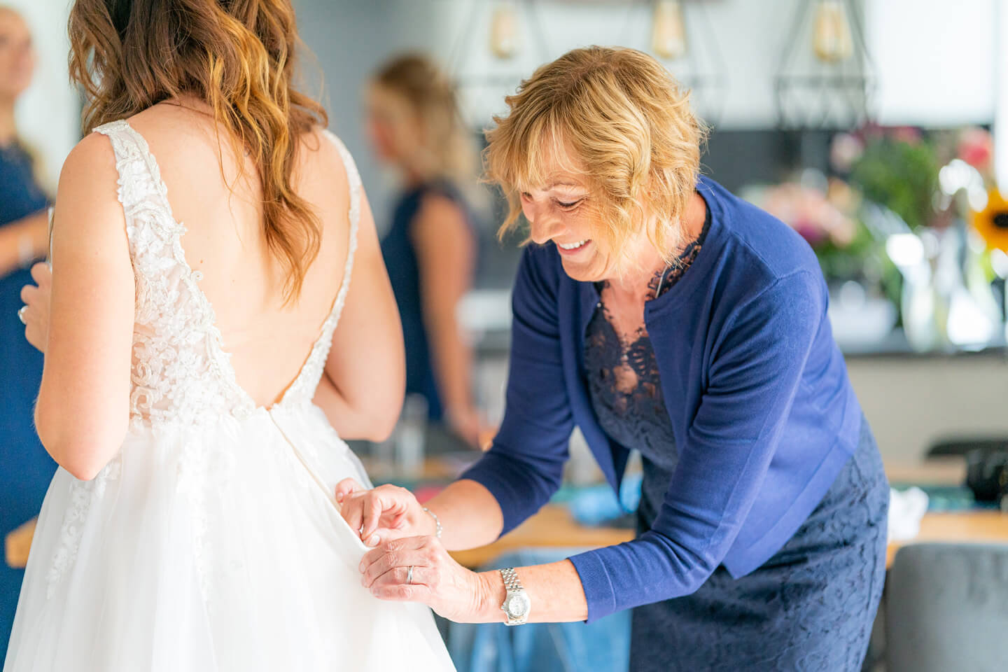 Mama hilft beim Schließen vom Brautkleid.
