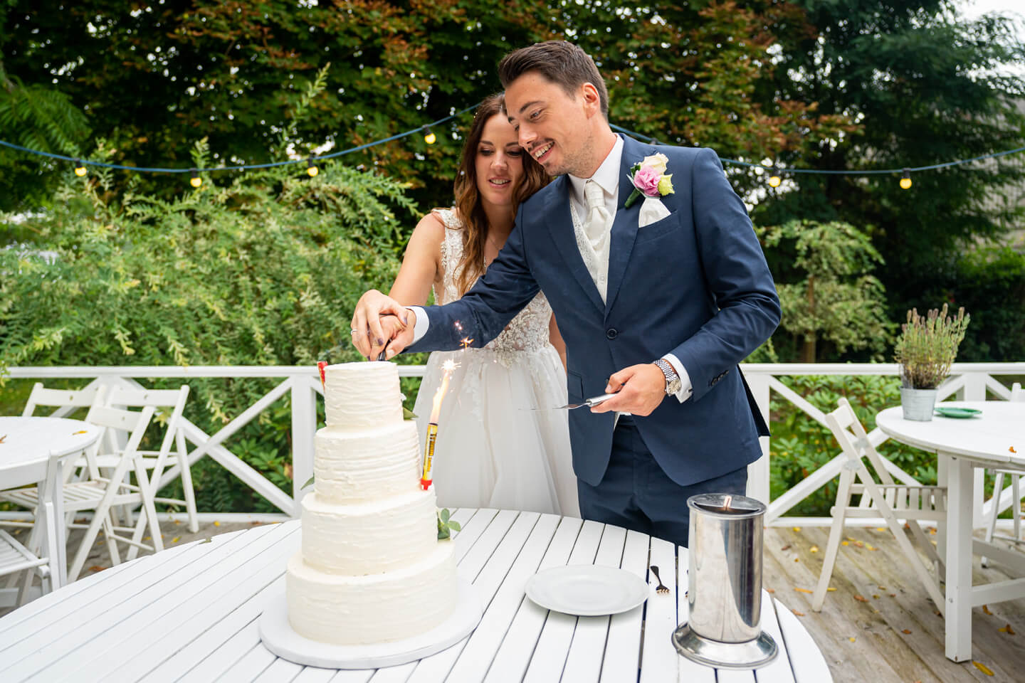 Anschnitt der Hochzeitstorte im Garten.