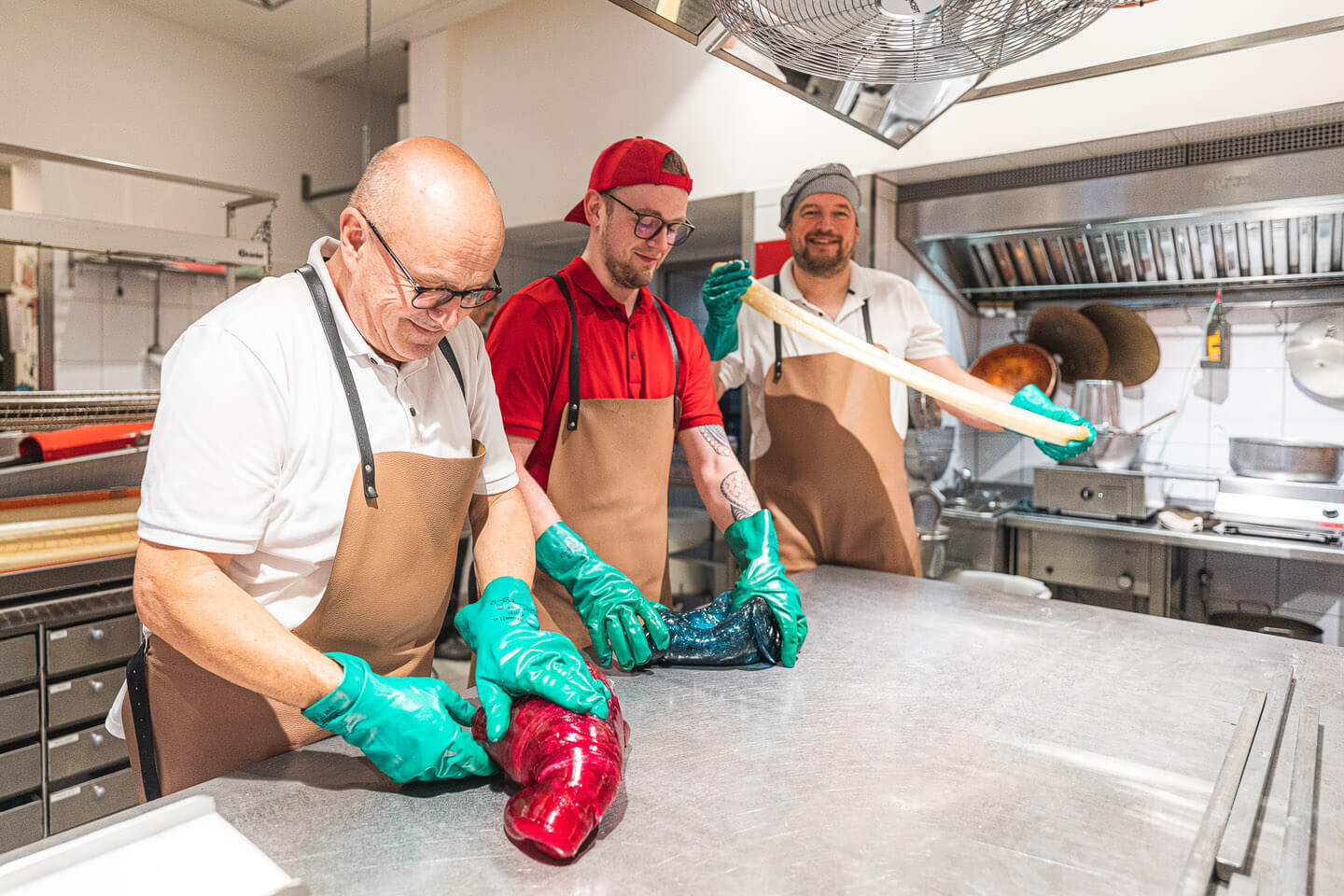 Drei Mann beim Teig kneten in der Zubereitung