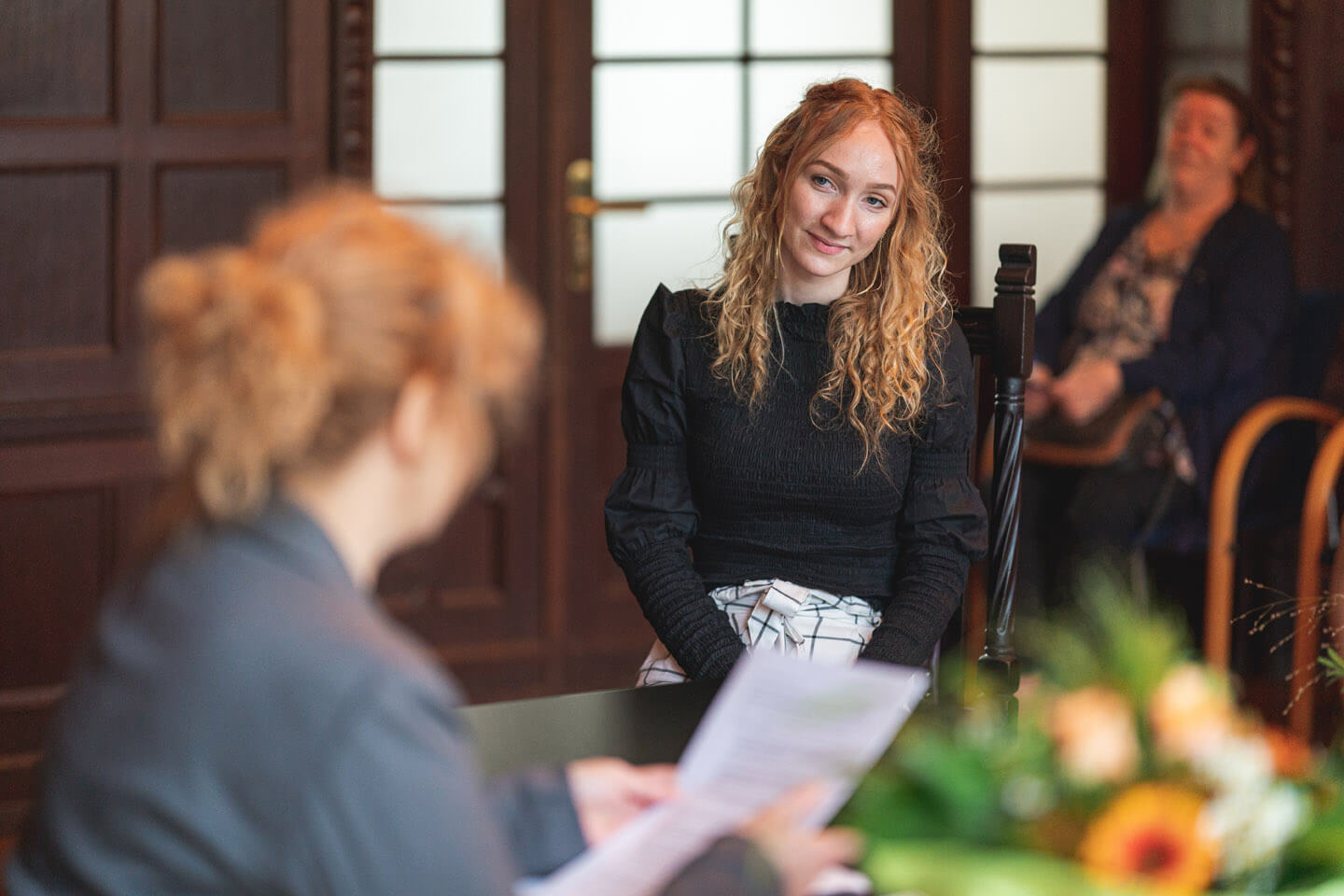 Die Trauzeugin lauscht der Standesbeamtin.