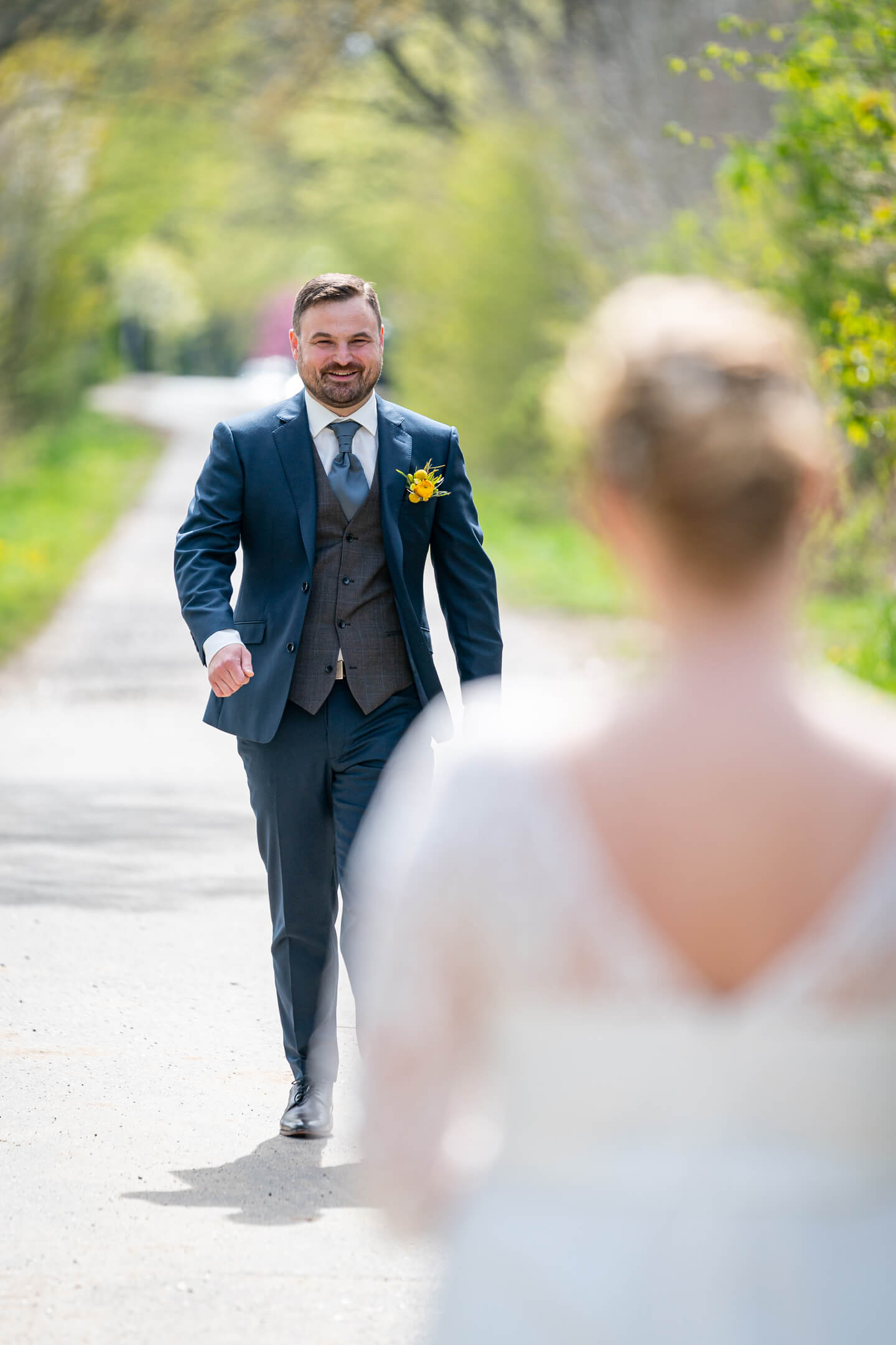 Bräutigam geht beim First Look Fotoshooting auf seine Braut zu.
