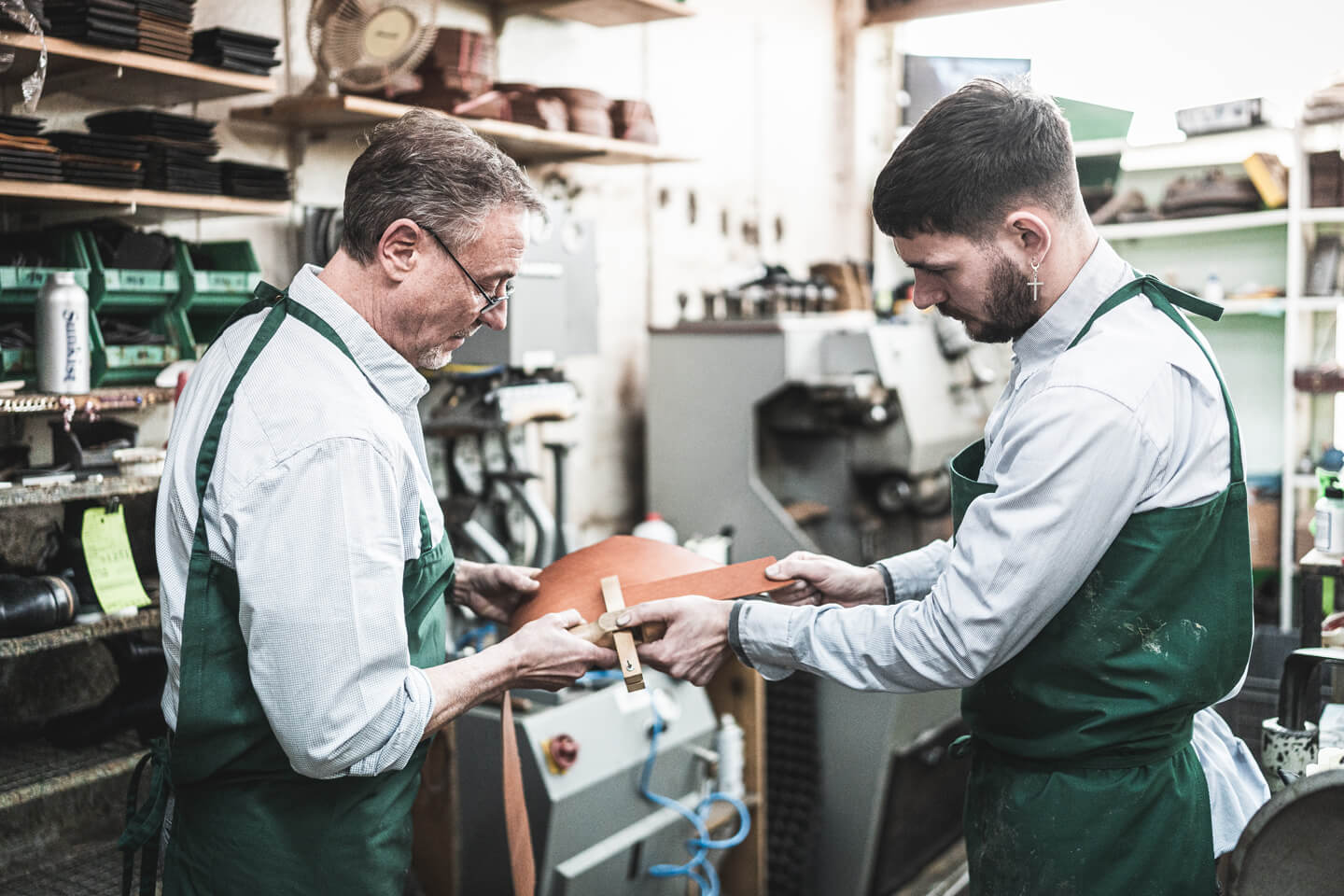 Meister und Auszubildender in der Schuhmacherei Bartold.