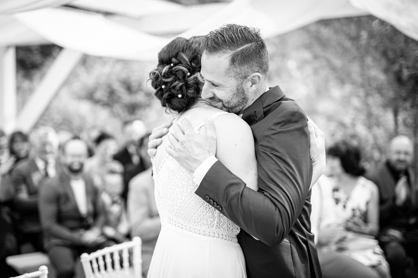 Brautpaar nimmt sich frisch verheiratet in den Arm.