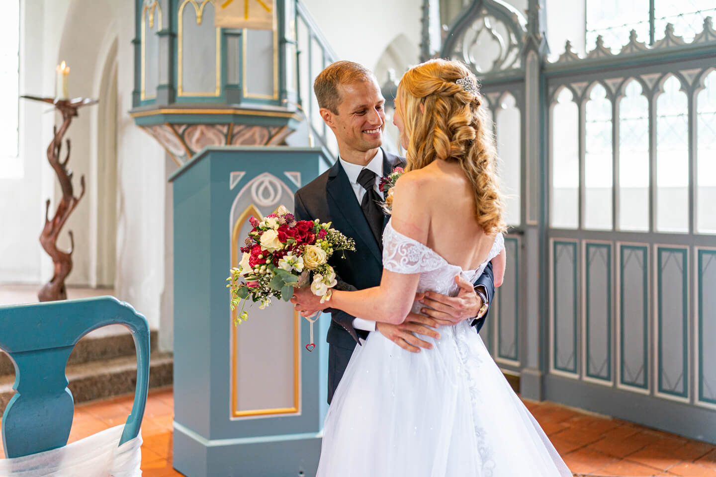 Bräutigam nimmt seine Braut am Altar in Empfang.