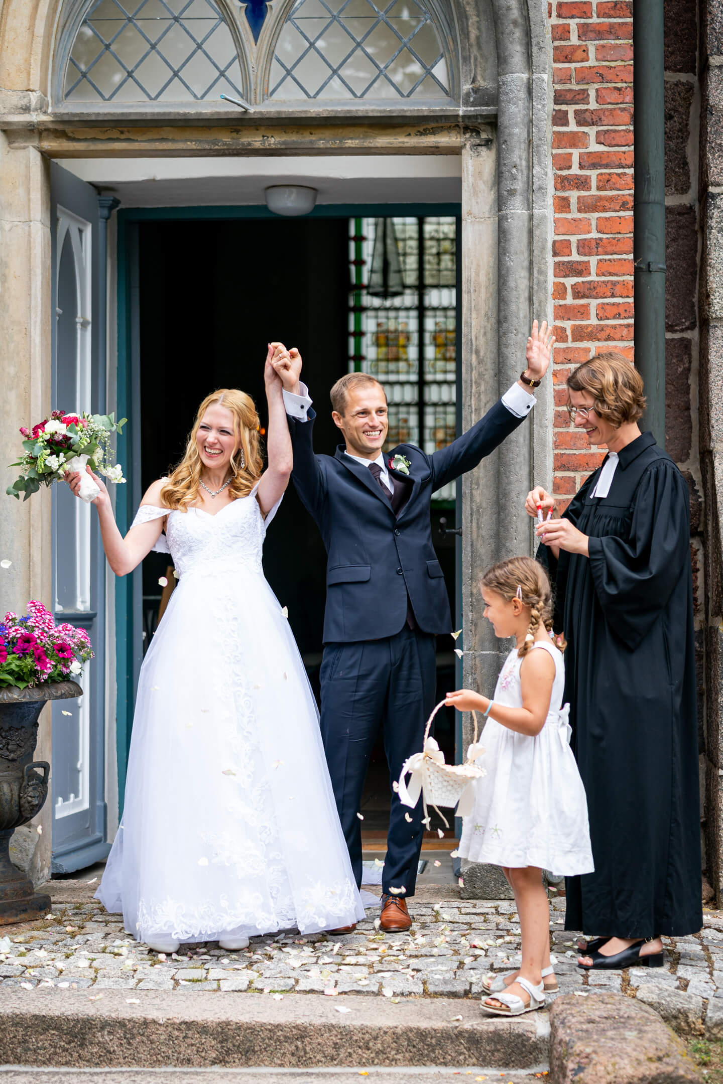 Brautpaar jubelt nach der kirchlichen Hochzeit.