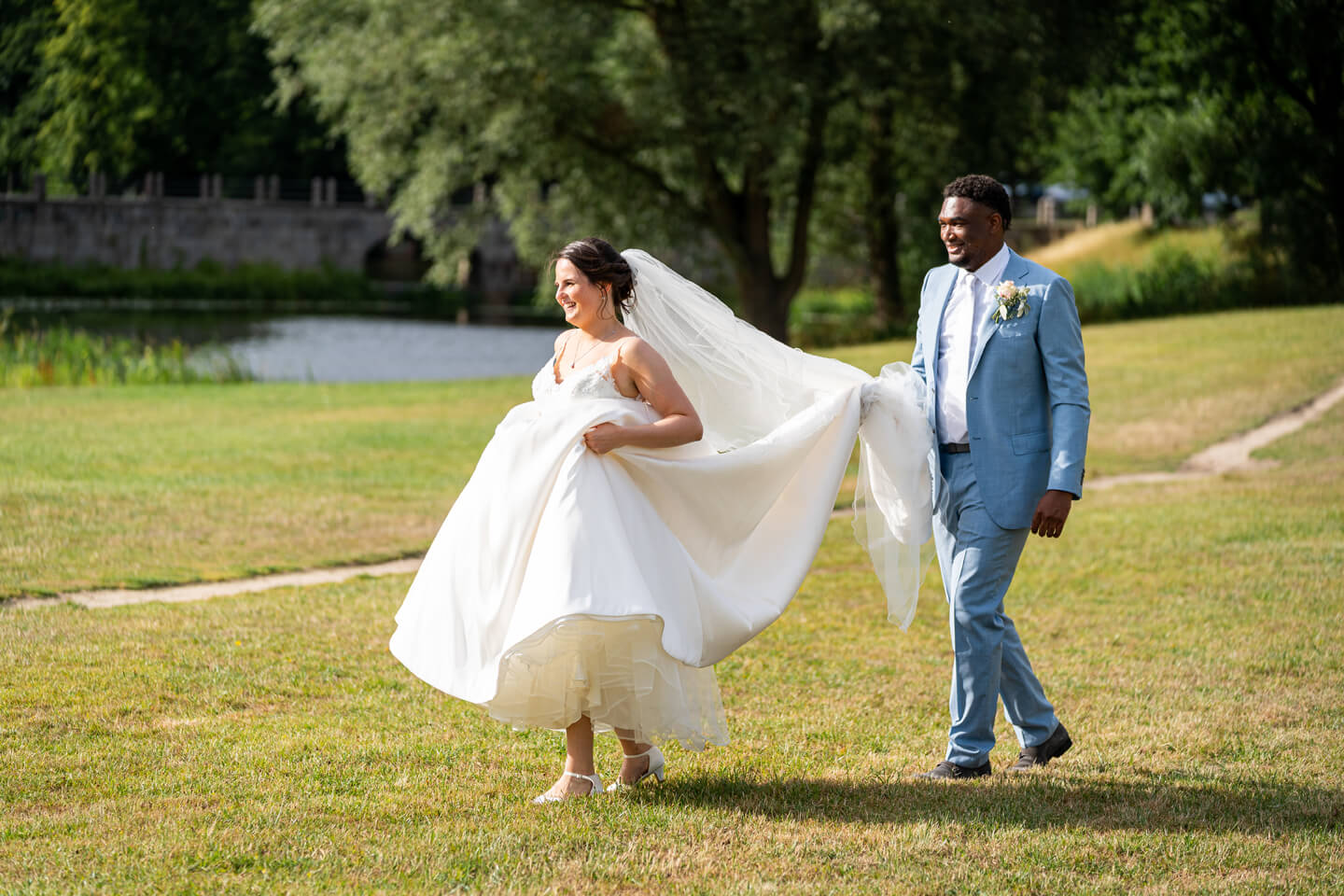 Outtake: Bräutigam trägt Schleppe der Braut.