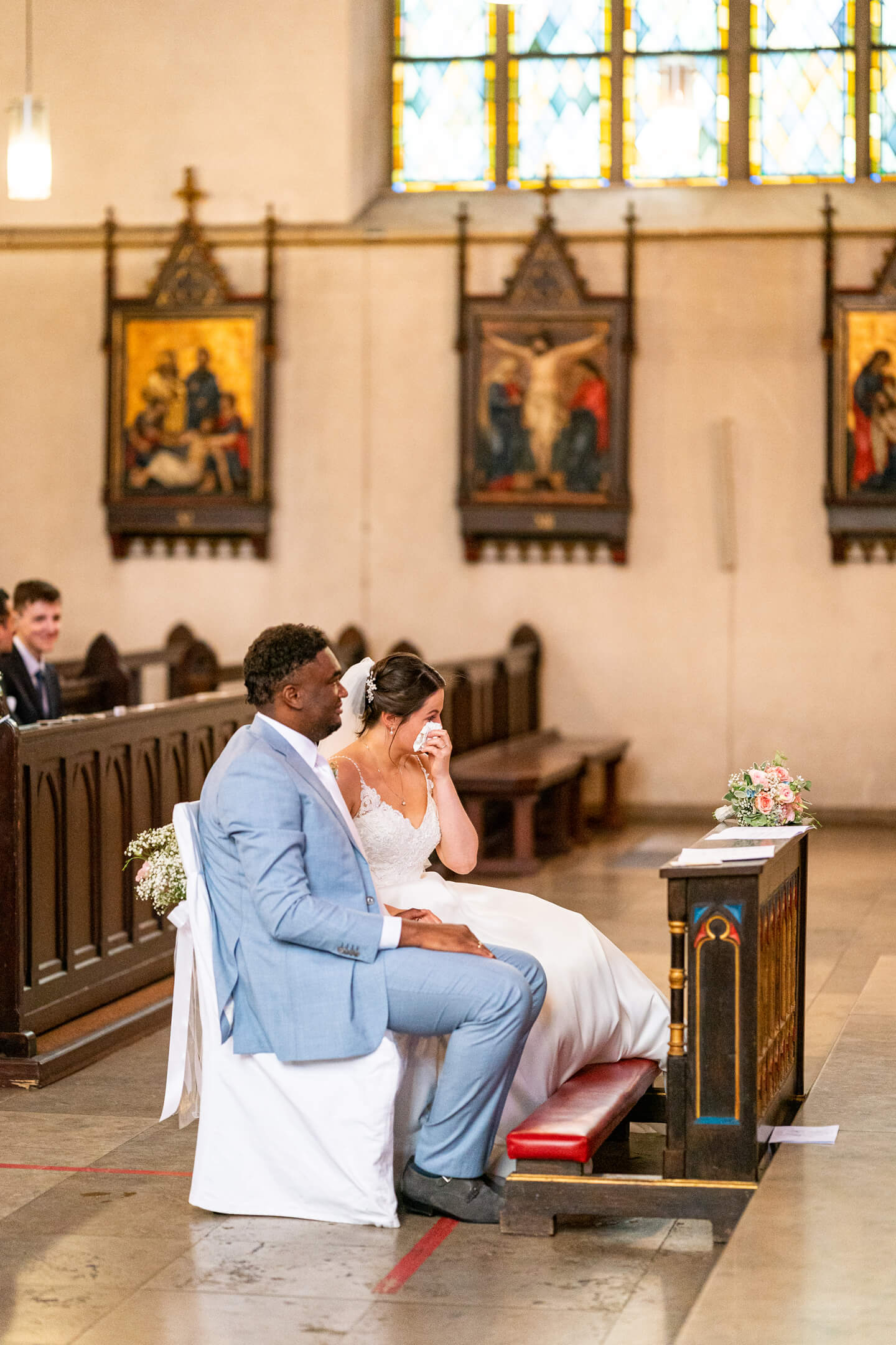 Braut wischt sich am Altar eine Träne weg.