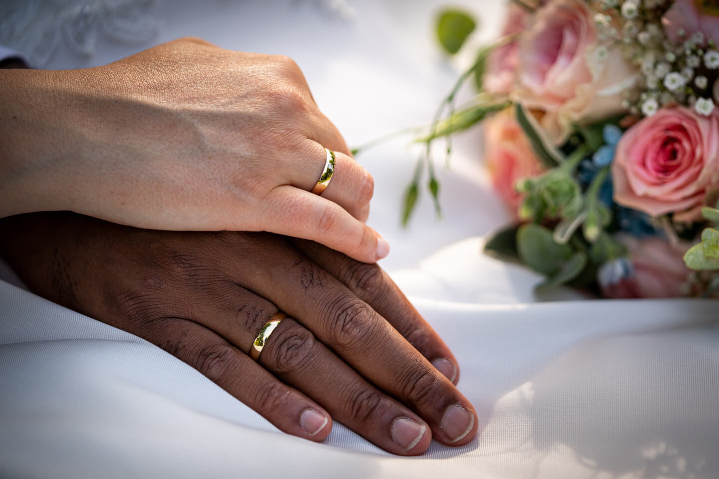 Eheringe an den Händen des Brautpaares.