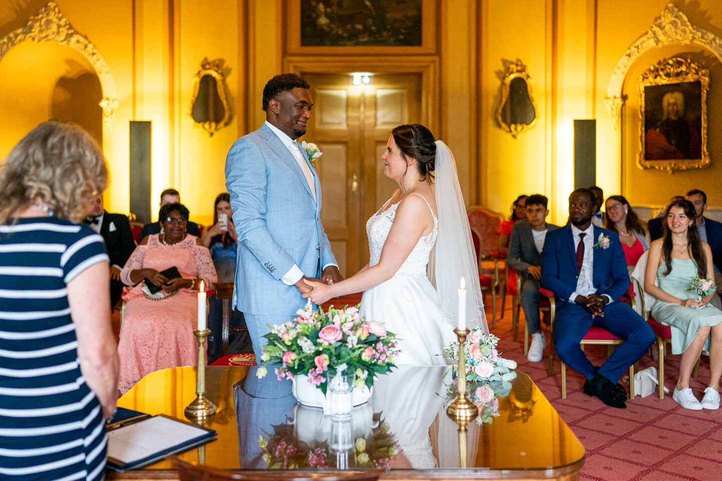 Hochzeitspaar steht sich bei der Trauung im Schloss Ahrensburg gegenüber.