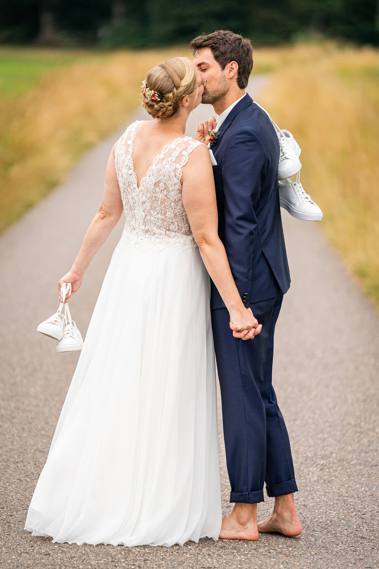 Hochzeitspaar läuft barfuss und küsst sich dabei. Fotograf: Florian Läufer