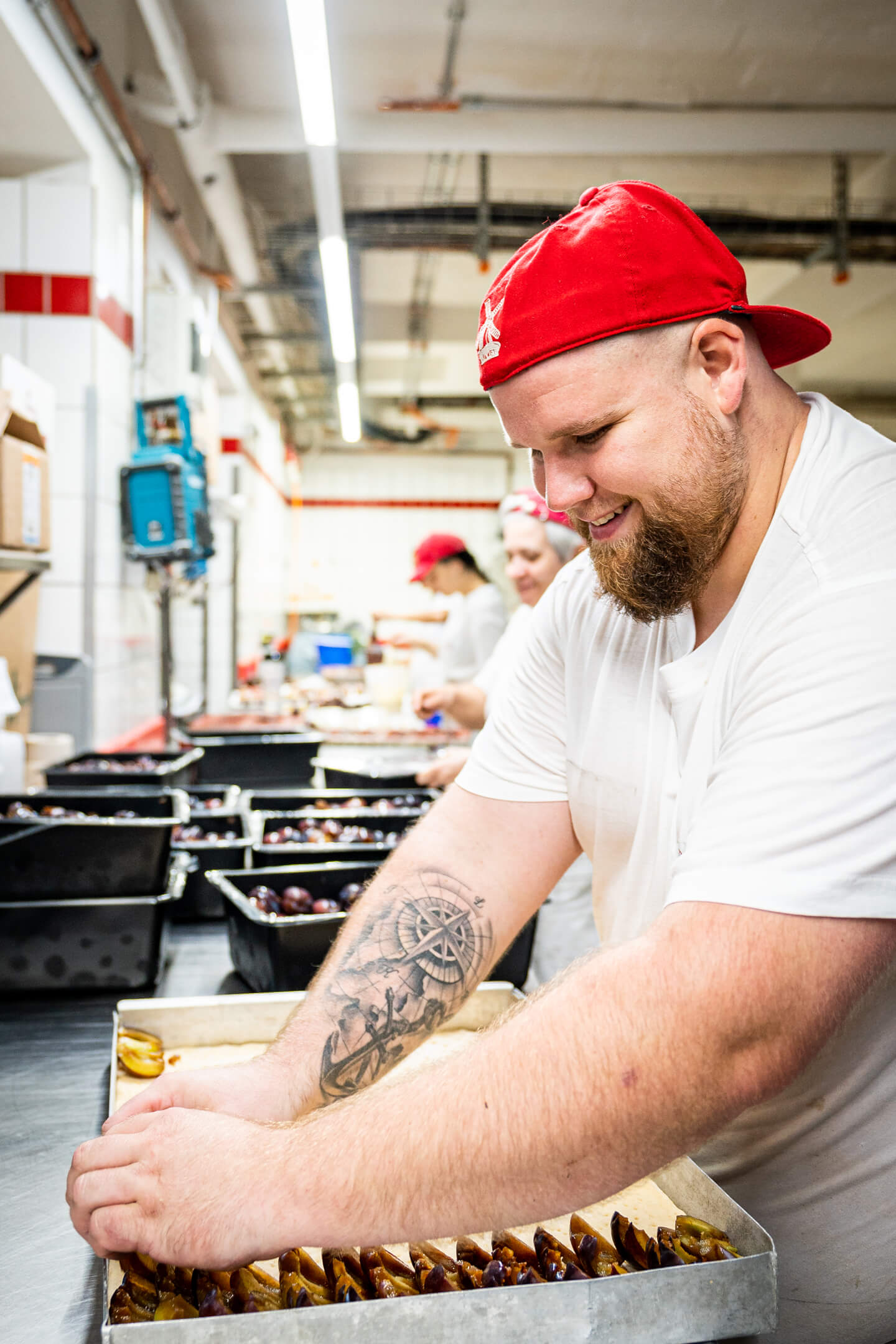 Konditor belegt Pflaumenkuchen
